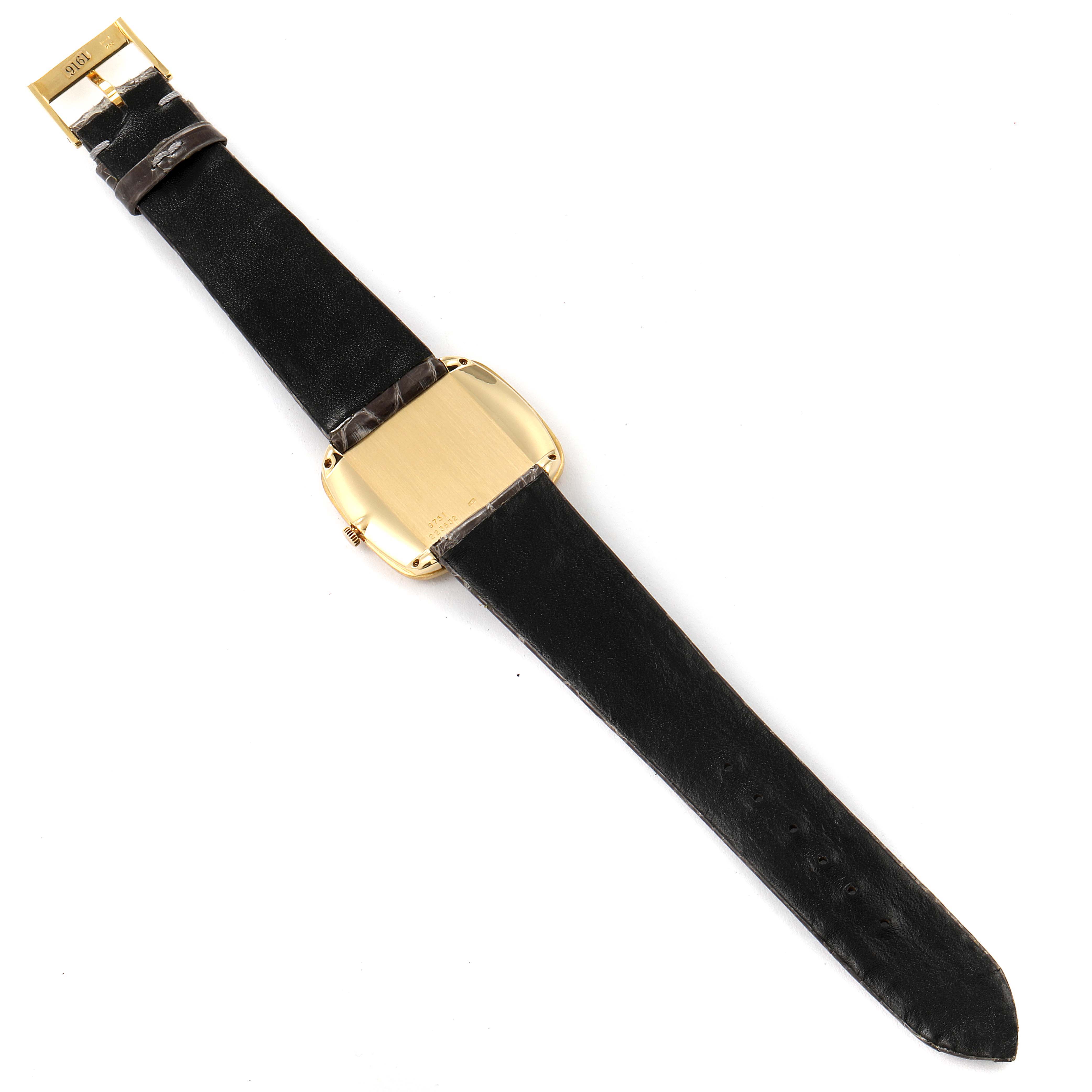 This Piaget 9751 Men's Yellow Gold Black Dial 9751 Men's Yellow Gold Black Dial 9751 men's watch is shown from the back, displaying its grey strap and 18K yellow gold case.