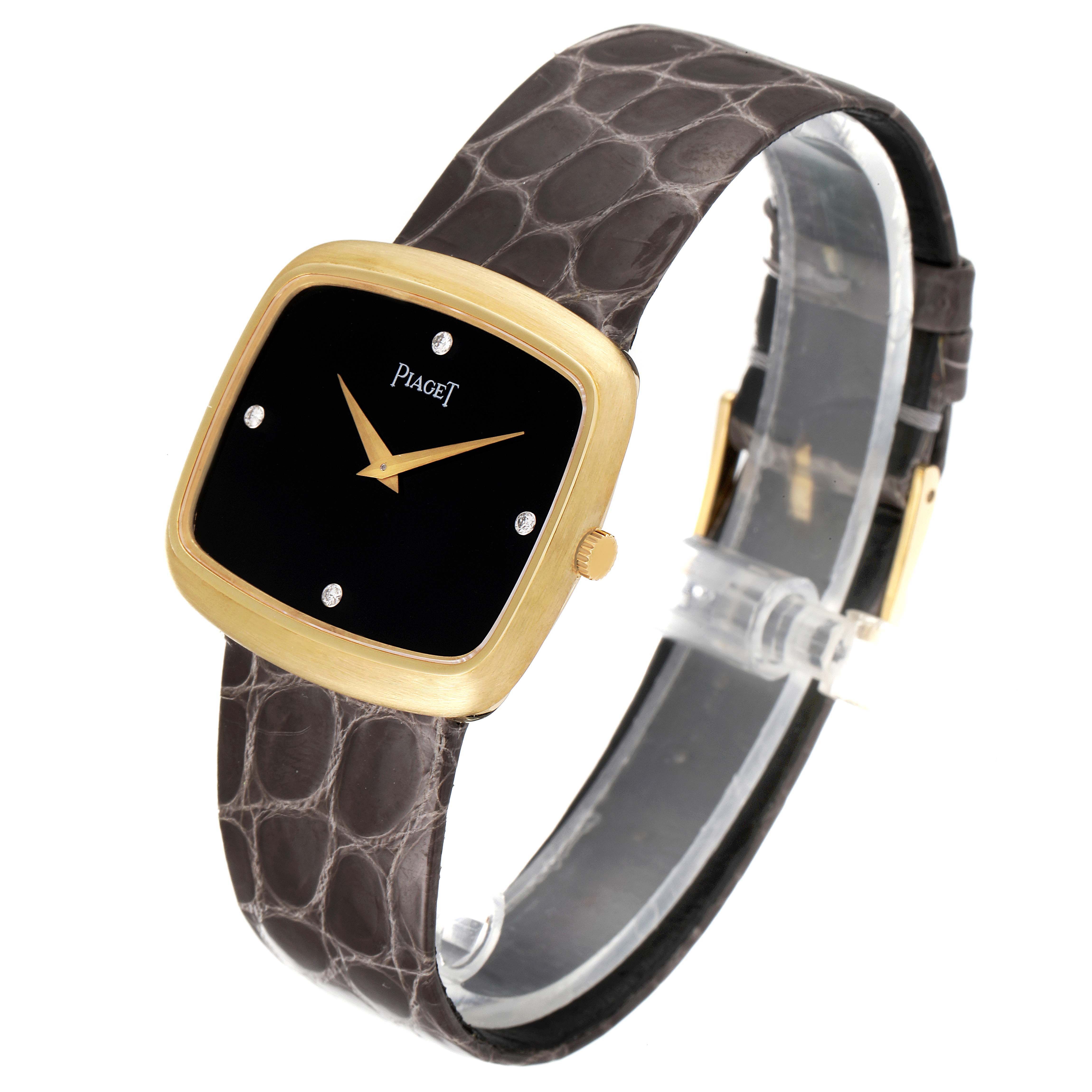 The Piaget 9751 Men's Yellow Gold Black Dial 9751 Men's Yellow Gold Black Dial 9751 model watch is shown at a three-quarter angle, highlighting its 18K yellow gold case, black diamond dial, and grey strap.