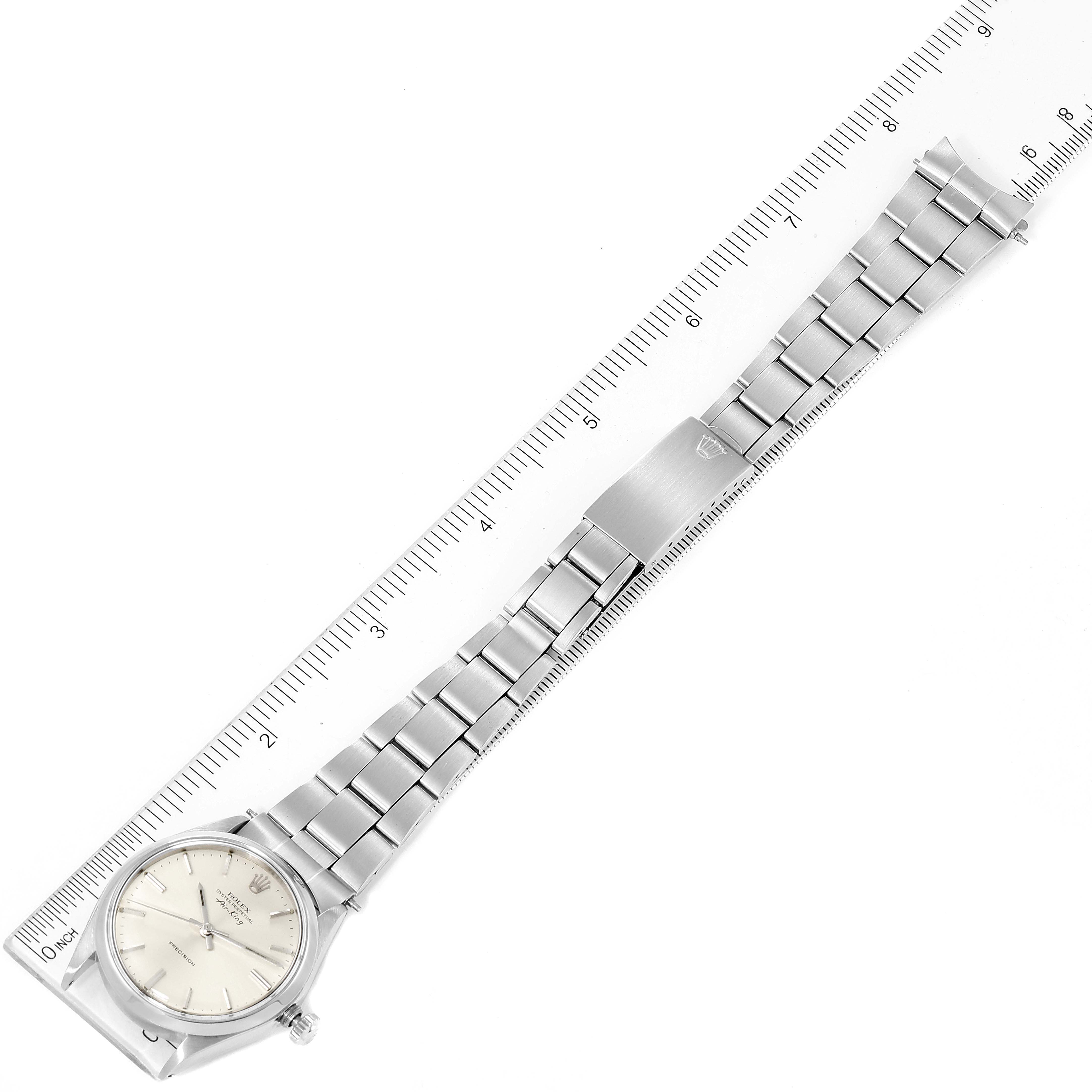 The image shows a top view of the Rolex Vintage Collection 5500 Men
s Stainless Steel Silver Dial 5500 Men
s Stainless Steel Silver Dial watch, highlighting its full bracelet and watch face alongside a ruler for scale.