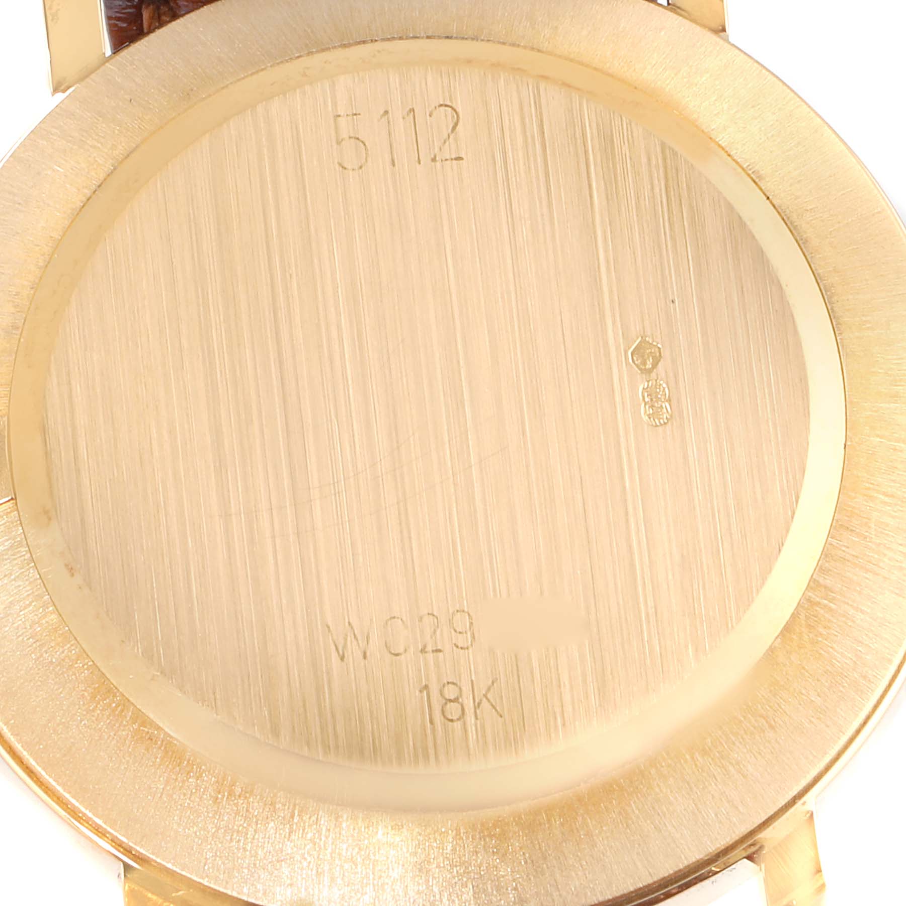 The image shows the back case of a Rolex Cellini 5112 Men's Yellow Gold Champagne Dial 5112 Men's Yellow Gold Champagne Dial model watch featuring engravings and markings.