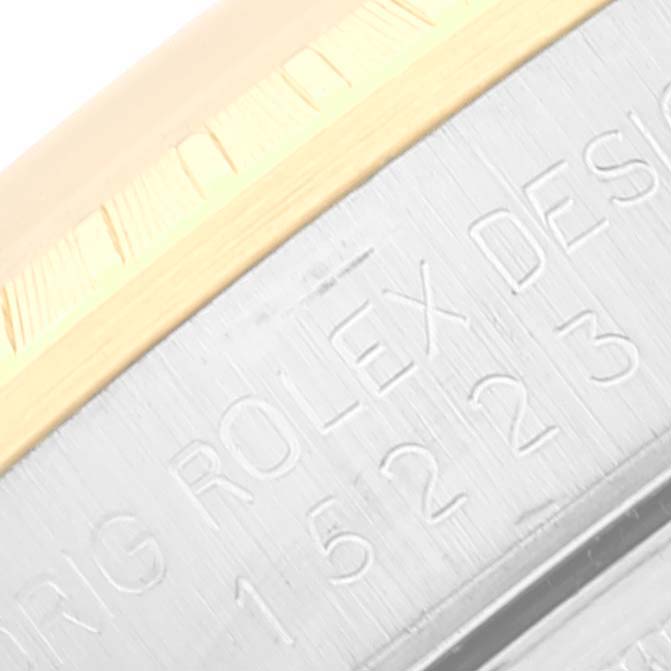 This image shows a close-up of the case and bezel of a Rolex Date 15223 Men's Steel and Gold (two tone) White Dial 15223 Men's Steel and Gold (two tone) White Dial model watch, focusing on the engraved text.