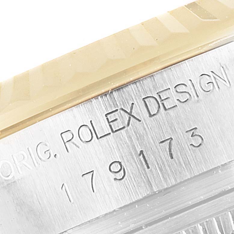 The image shows a close-up of the engraved serial number and "ROLEX DESIGN" text on the side of a Rolex Datejust 179173 Women's Steel and Gold (two tone) Green Dial 179173 Women's Steel and Gold (two tone) Green Dial watch case.