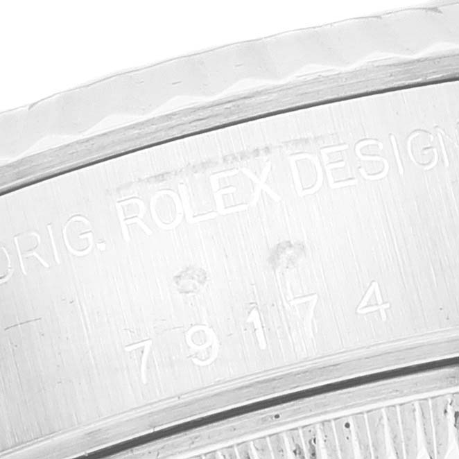 This image shows an engraving on the side of the case of a Rolex Datejust 79174 Women's Stainless Steel Silver Dial 79174 Women's Stainless Steel Silver Dial watch.