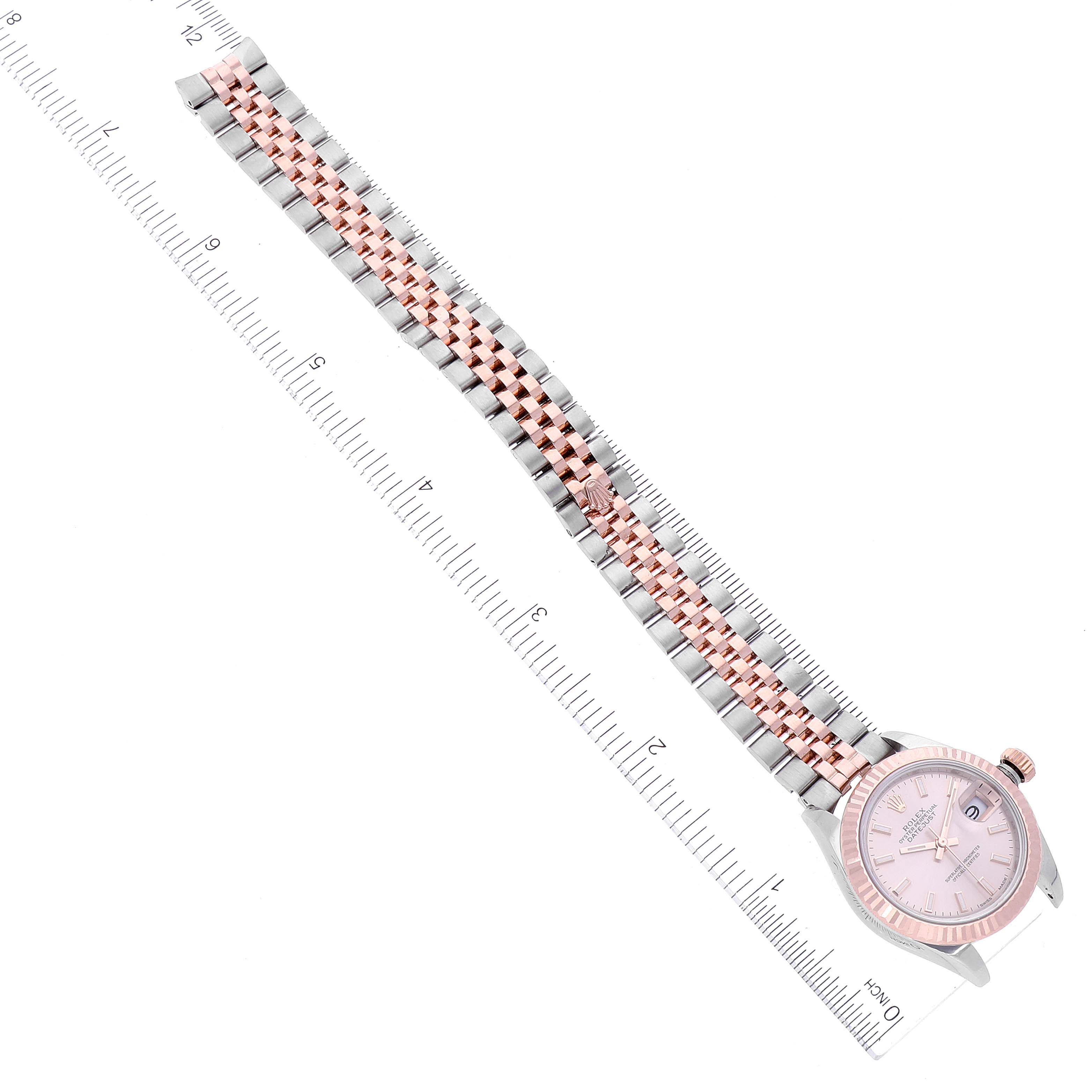 This image shows a Rolex Datejust 279171 Women's Steel and Gold (two tone) Pink Dial 279171 Women's Steel and Gold (two tone) Pink Dial watch positioned at an angle, highlighting its bracelet and face with a measurement ruler.