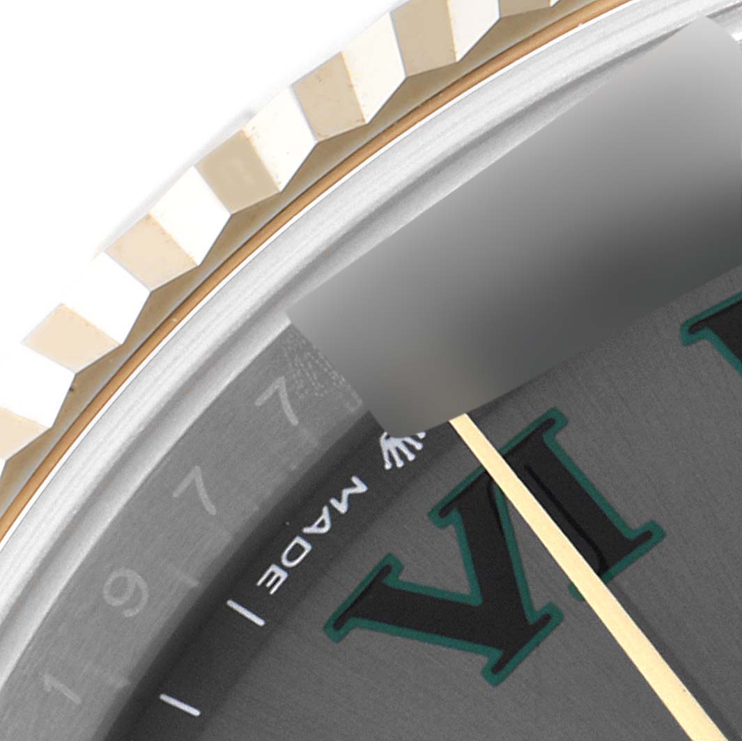 This close-up image of the Rolex Datejust 41 126333 Men
s Steel and Gold (two tone) Grey Dial 126333 Men
s Steel and Gold (two tone) Grey Dial shows the fluted bezel, part of the dial, and the minute hand.