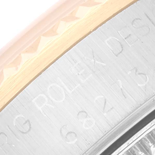 The image shows a close-up of the engraving on the side of the bezel and case of a Rolex Mid-Size 68273 Women
s Steel and Gold (two tone) Black Dial 68273 Women
s Steel and Gold (two tone) Black Dial watch.