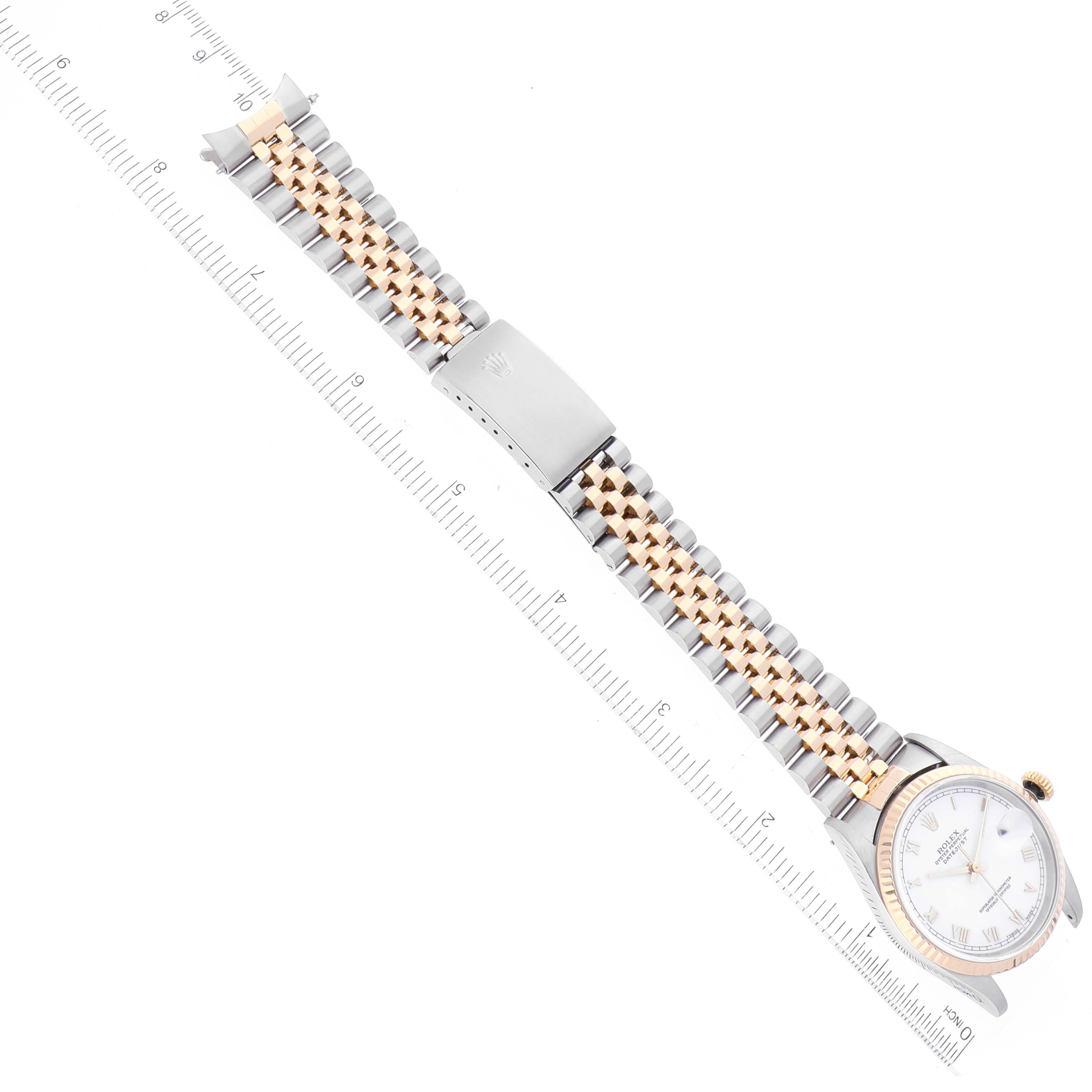 This top-view image shows a Rolex Datejust 16233 Men's Steel and Gold (two tone) White Dial 16233 Men's Steel and Gold (two tone) White Dial watch with its face partially visible and the full bracelet laid flat next to a ruler.