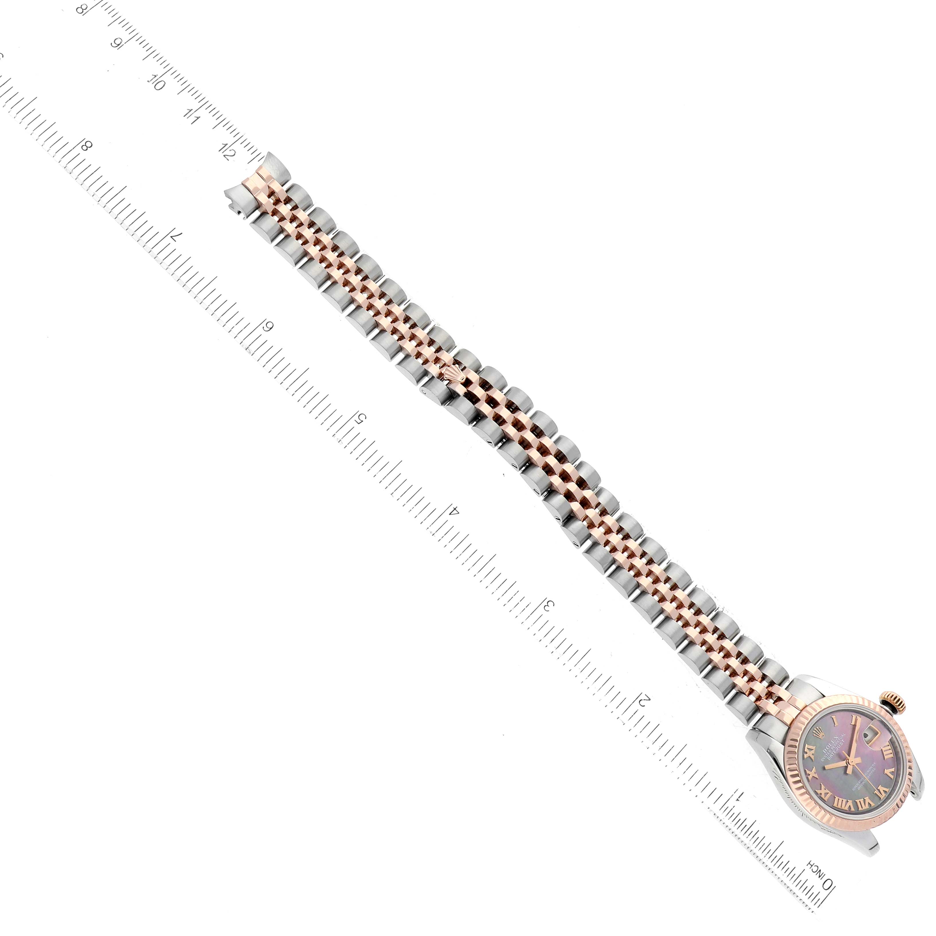 The image shows a Rolex Datejust 179171 Women's Steel and Gold (two tone) Mother of Pearl Dial 179171 Women's Steel and Gold (two tone) Mother of Pearl Dial watch displayed alongside a ruled scale, emphasizing its bracelet and watch face.