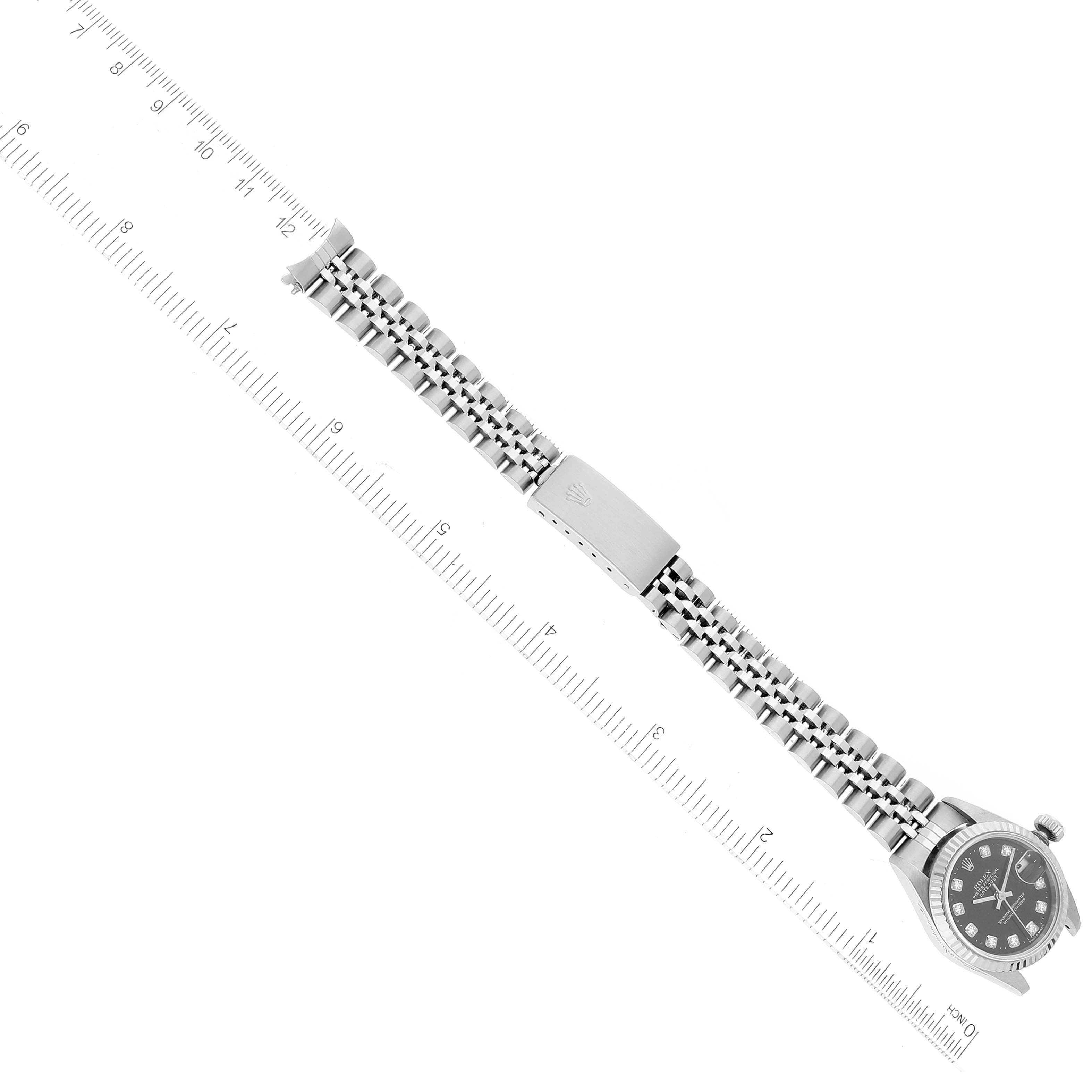This image shows a Rolex Datejust 69174 Women's Stainless Steel Black Dial 69174 Women's Stainless Steel Black Dial watch at a top-down angle, displaying the face, bracelet, and clasp alongside a measuring ruler.