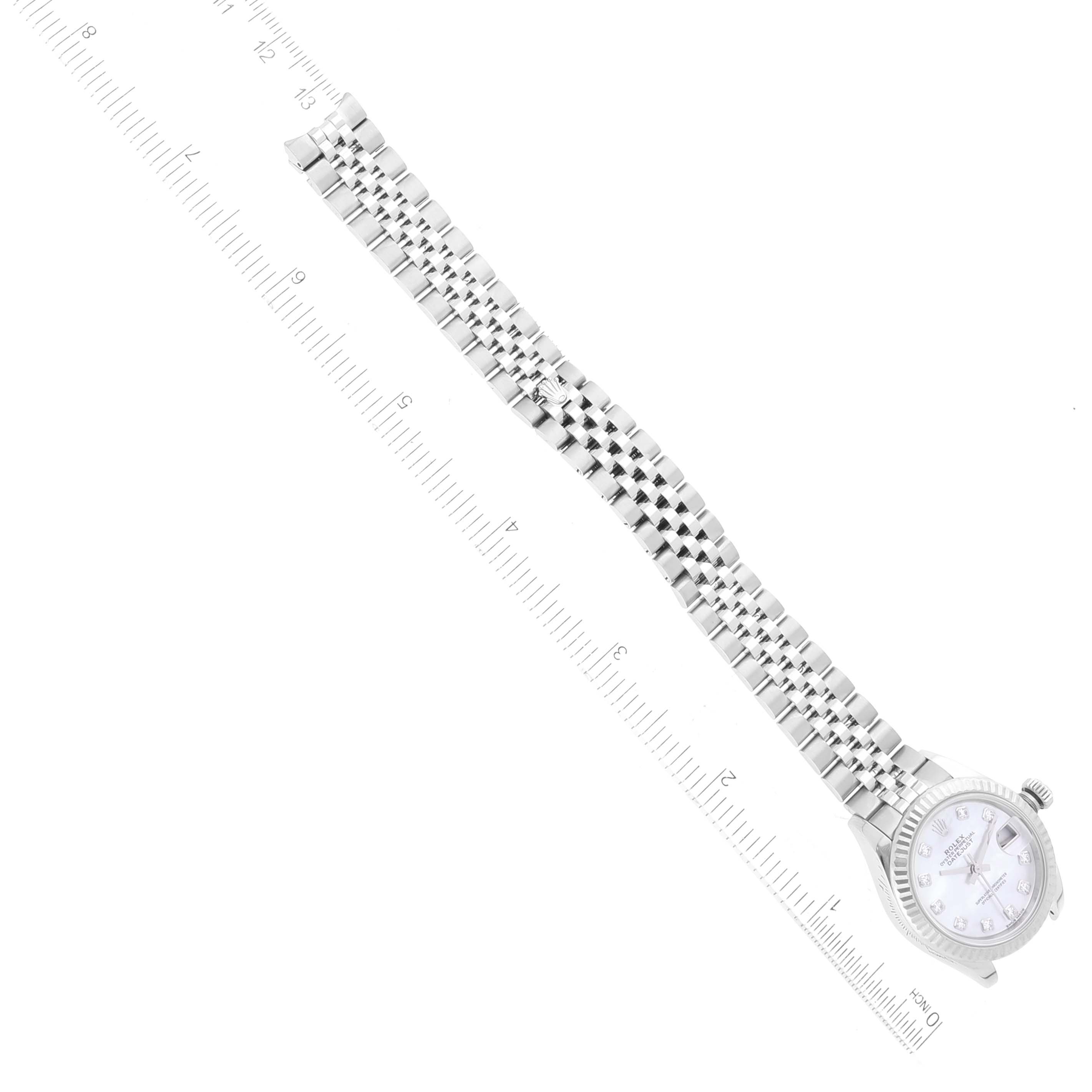 This image shows a Rolex Datejust 279174 Women
s Stainless Steel Mother of Pearl Dial 279174 Women
s Stainless Steel Mother of Pearl Dial watch laid out flat beside a ruler, displaying its face and bracelet.