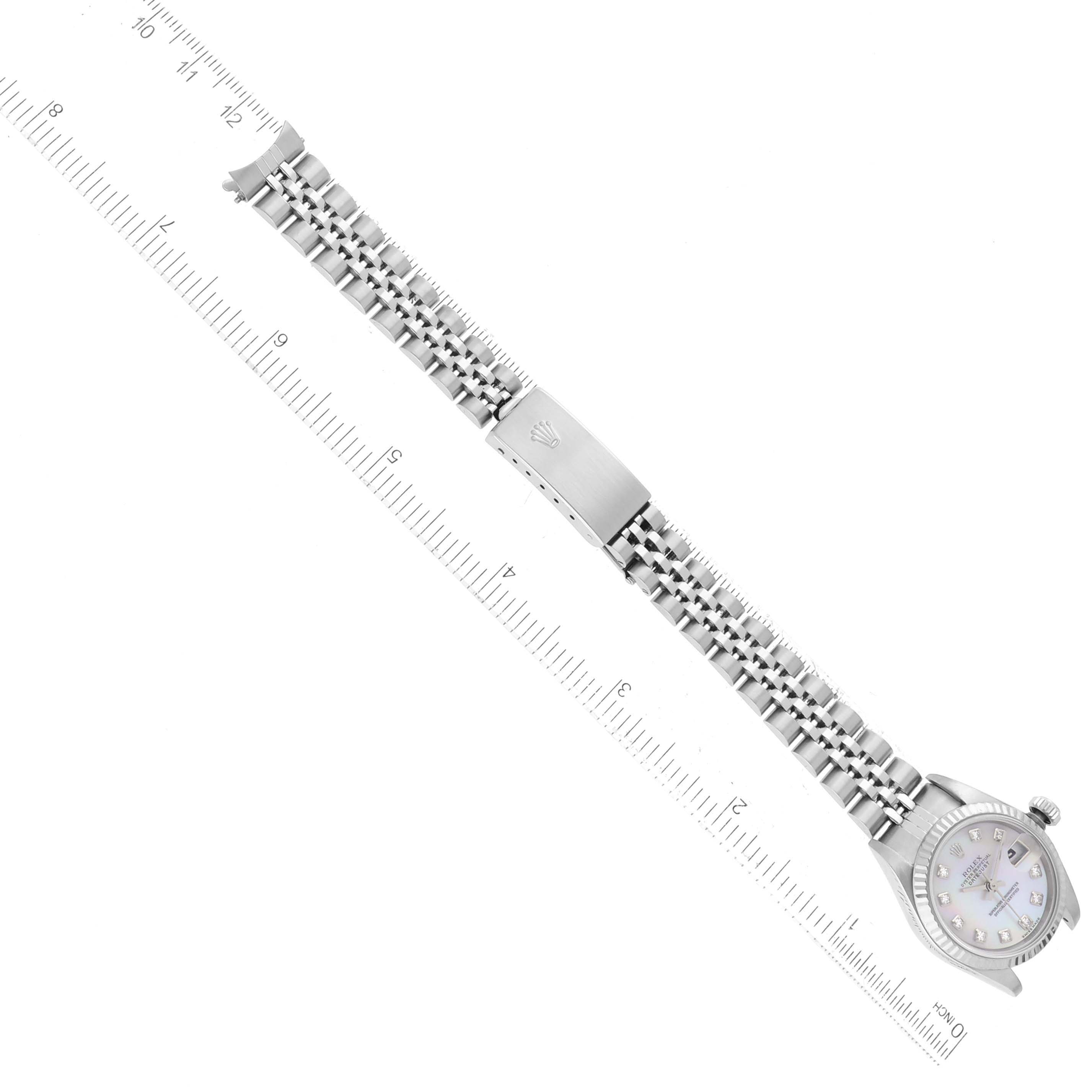 The image shows a Rolex Datejust 79174 Women's Steel and Gold (two tone) Mother of Pearl Dial 79174 Women's Steel and Gold (two tone) Mother of Pearl Dial watch laid flat with its bracelet extended alongside a ruler for size reference.