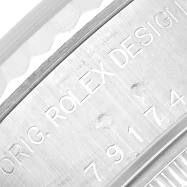 The image shows a close-up view of the Rolex Datejust 79174 Women's Steel and Gold (two tone) Mother of Pearl Dial 79174 Women's Steel and Gold (two tone) Mother of Pearl Dial model's bezel and serial number engraving.