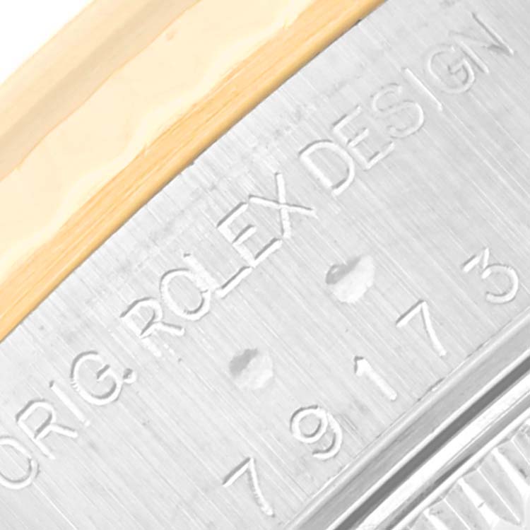 Close-up of the inner bezel of a Rolex Datejust 79173 Women's Steel and Gold (two tone) Black Dial 79173 Women's Steel and Gold (two tone) Black Dial, showing the engraved text and serial number.