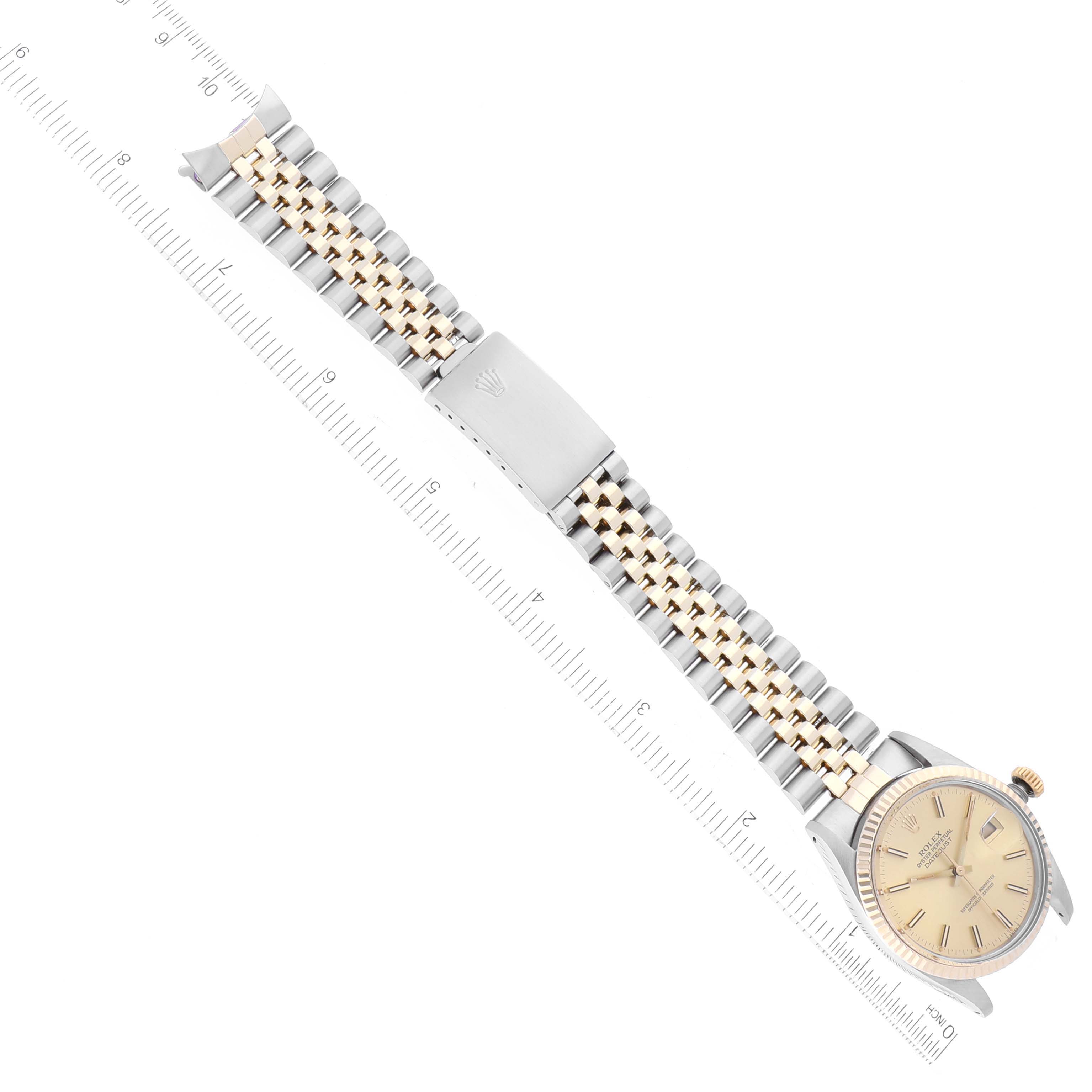 The Rolex Datejust 16013 Men's Steel and Gold (two tone) Champagne Dial 16013 Men's Steel and Gold (two tone) Champagne Dial is shown from a top-down angle, displaying the face, case, and entire bracelet with a ruler for scale.