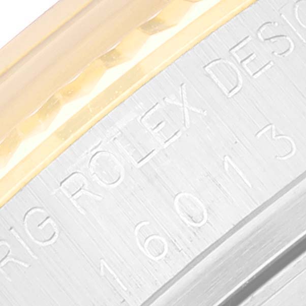 This close-up image shows the engraved serial number and part of the fluted bezel of a Rolex Datejust 16013 Men's Steel and Gold (two tone) Champagne Dial 16013 Men's Steel and Gold (two tone) Champagne Dial watch.