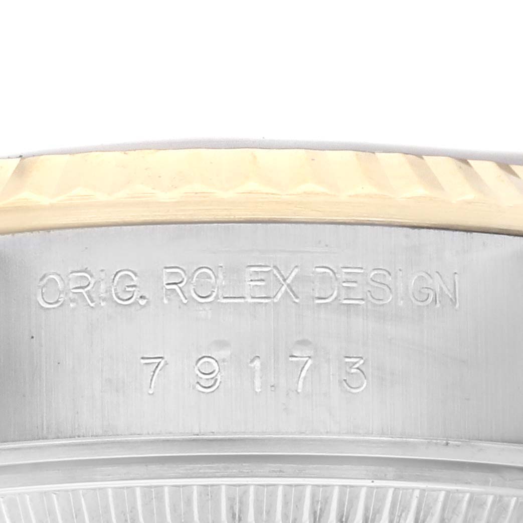 The image shows a close-up of the side of a Rolex Datejust 79173 Women's Steel and Gold (two tone) Champagne Dial 79173 Women's Steel and Gold (two tone) Champagne Dial watch, displaying the model number and the "ORIG. ROLEX DESIGN" engraving.