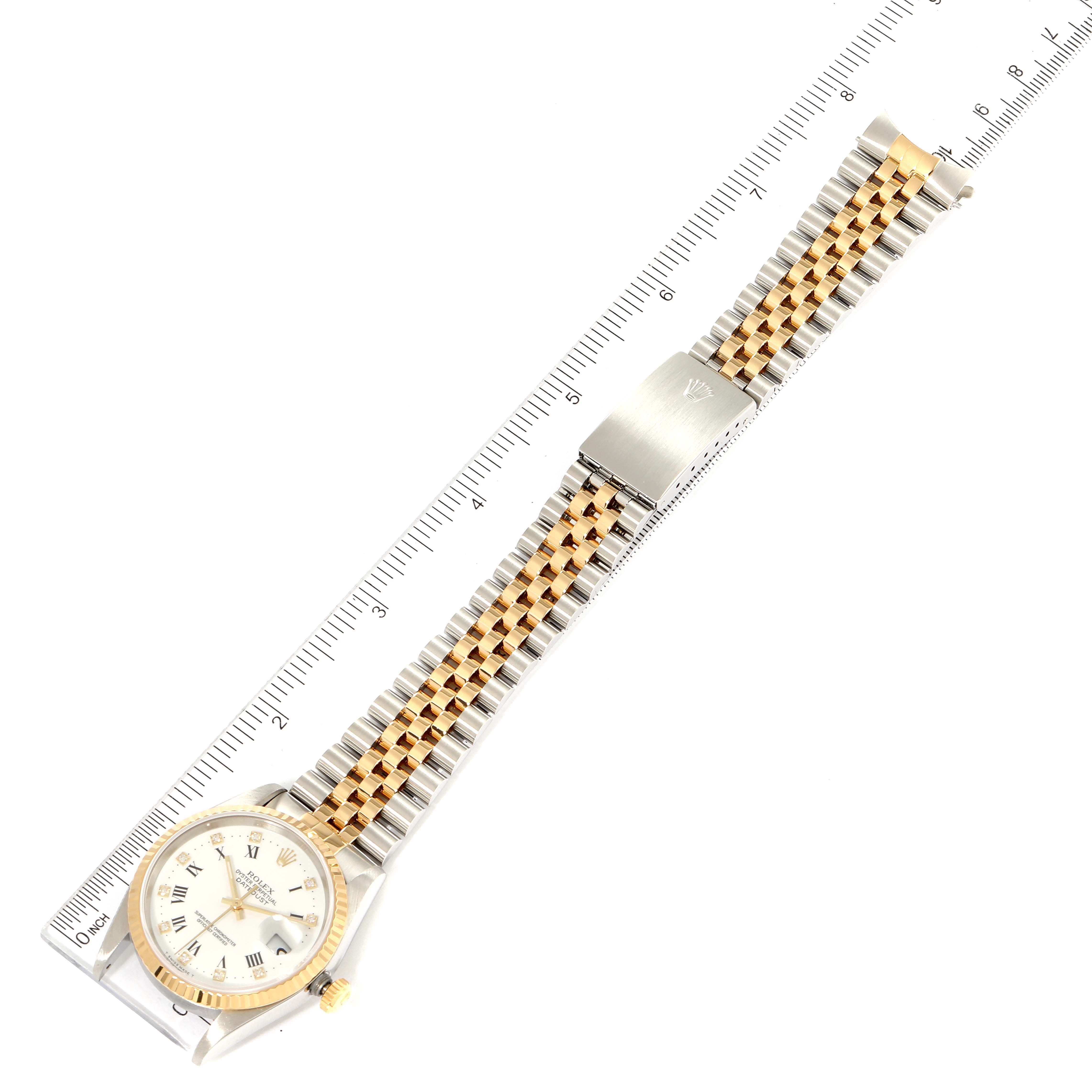 The image shows a Rolex Datejust 16233 Men's Steel and Gold (two tone) White Dial 16233 Men's Steel and Gold (two tone) White Dial watch laid flat with its face, bracelet, and clasp visible, aligned with a ruler for scale.