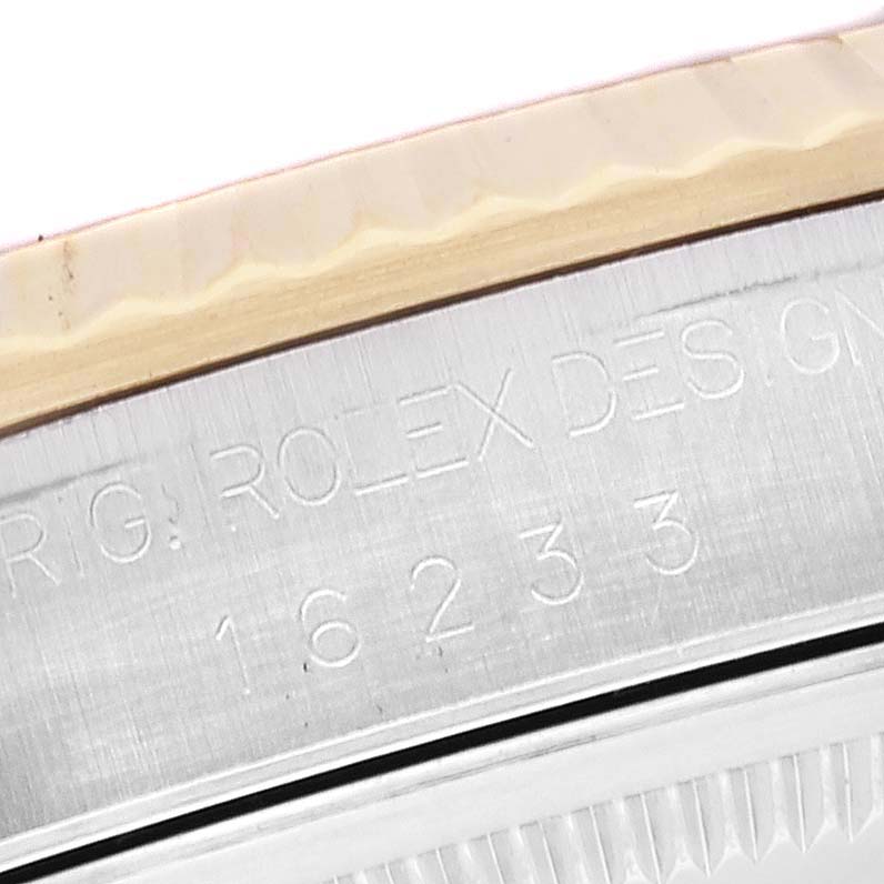 This image shows an extreme close-up of the model and serial number engraved on the side of a Rolex Datejust 16233 Men's Steel and Gold (two tone) Champagne Dial 16233 Men's Steel and Gold (two tone) Champagne Dial watch case.