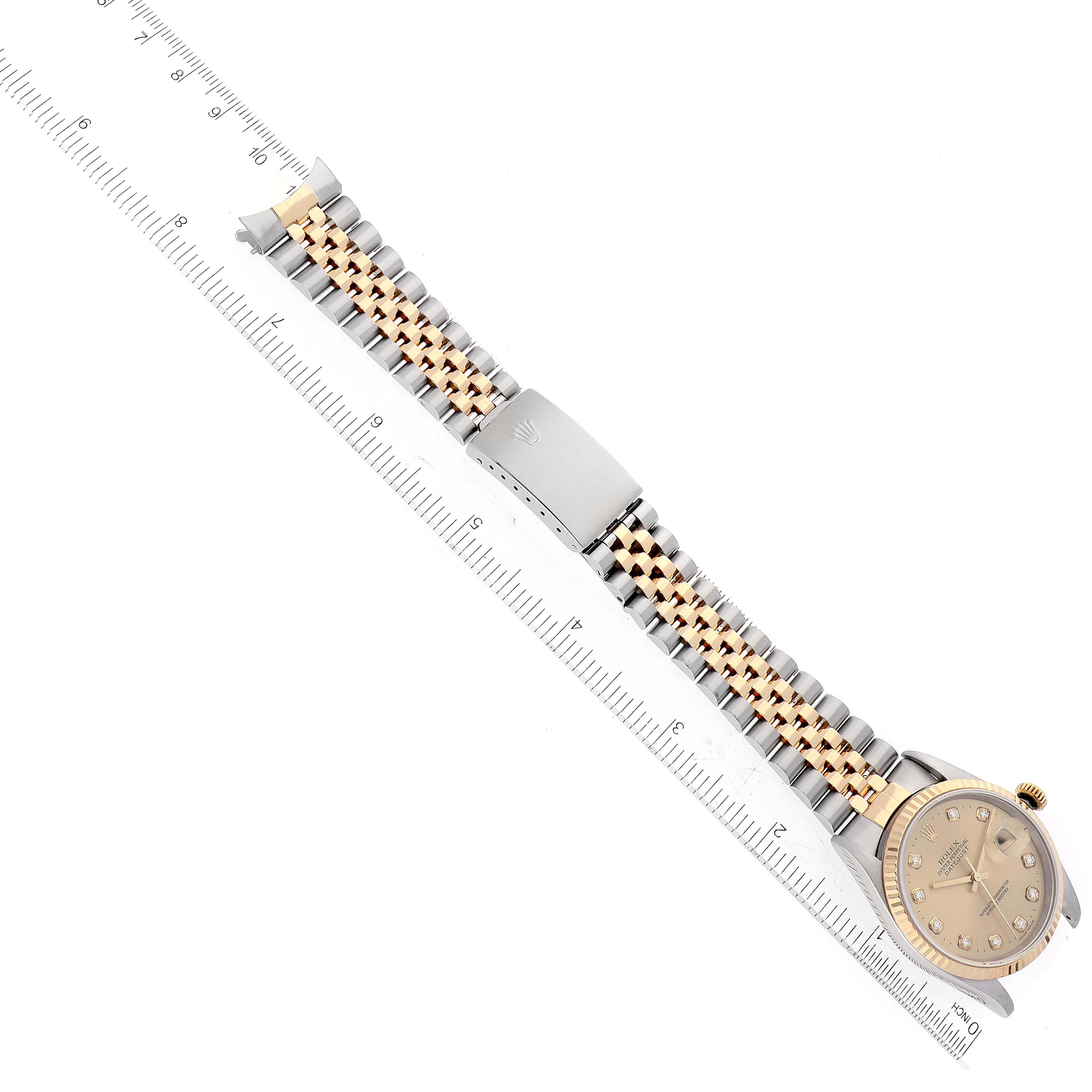 The Rolex Datejust 16233 Men's Steel and Gold (two tone) Champagne Dial 16233 Men's Steel and Gold (two tone) Champagne Dial watch is shown from a top-down angle, displaying the face, bezel, and metal bracelet with a ruler for scale.