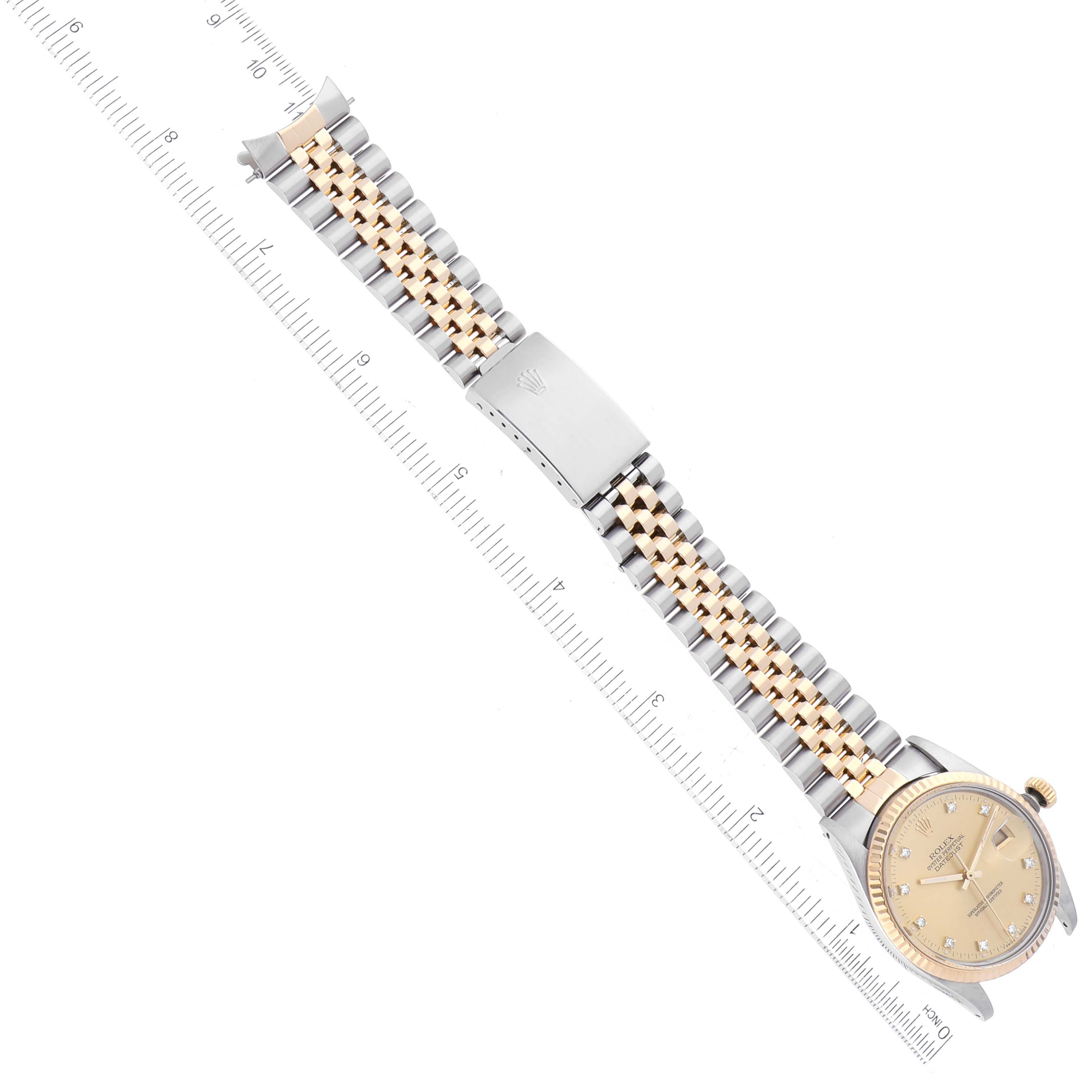 The Rolex Datejust 16013 Men's Steel and Gold (two tone) Champagne Dial 16013 Men's Steel and Gold (two tone) Champagne Dial watch is shown in a top-down angle, highlighting its face, bracelet, and clasp against a ruler for scale.