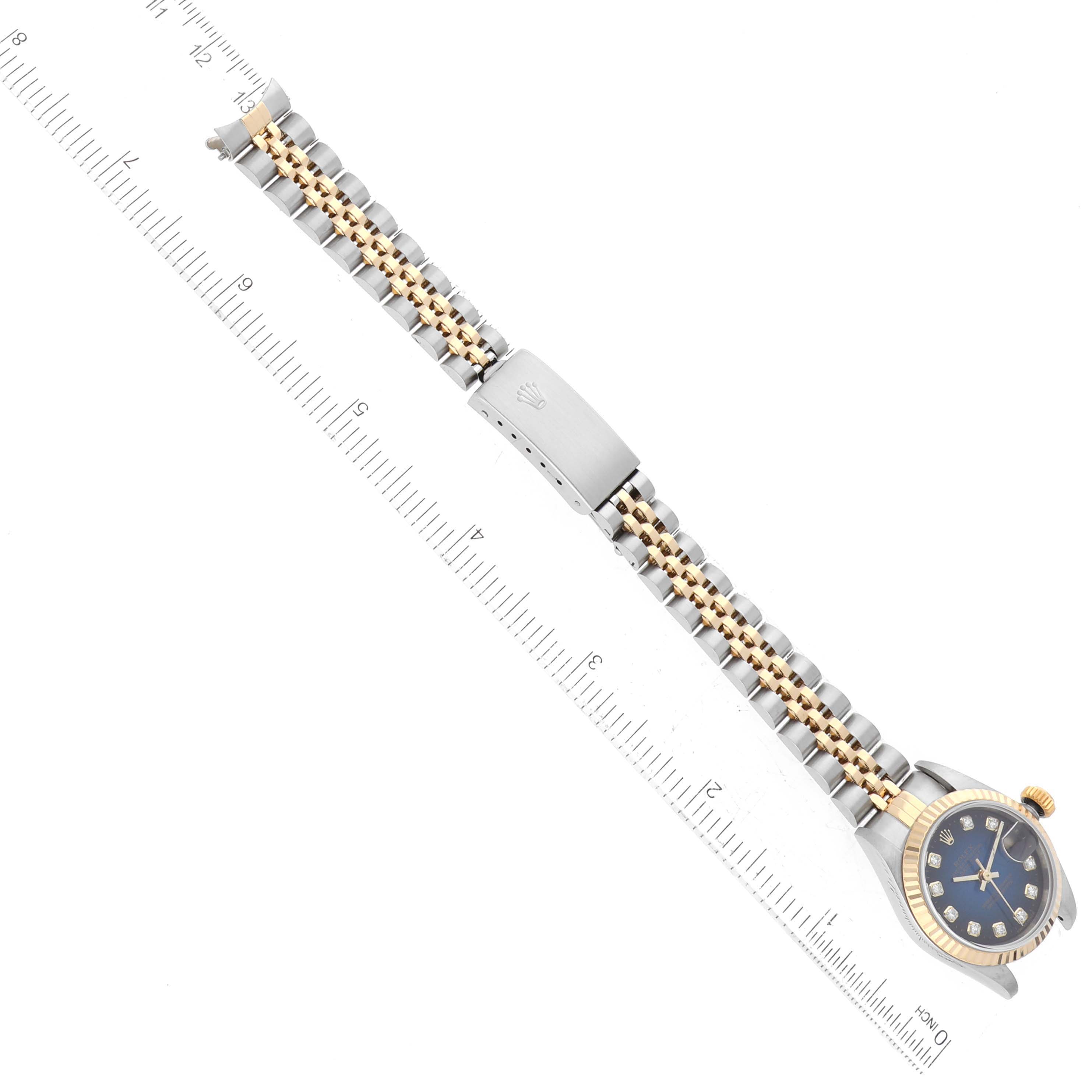 The image shows a Rolex Datejust 79173 Women's Steel and Gold (two tone) Blue Dial 79173 Women's Steel and Gold (two tone) Blue Dial watch with a gold and silver bracelet, a closed clasp, and a partially visible blue dial, measured against a ruler.