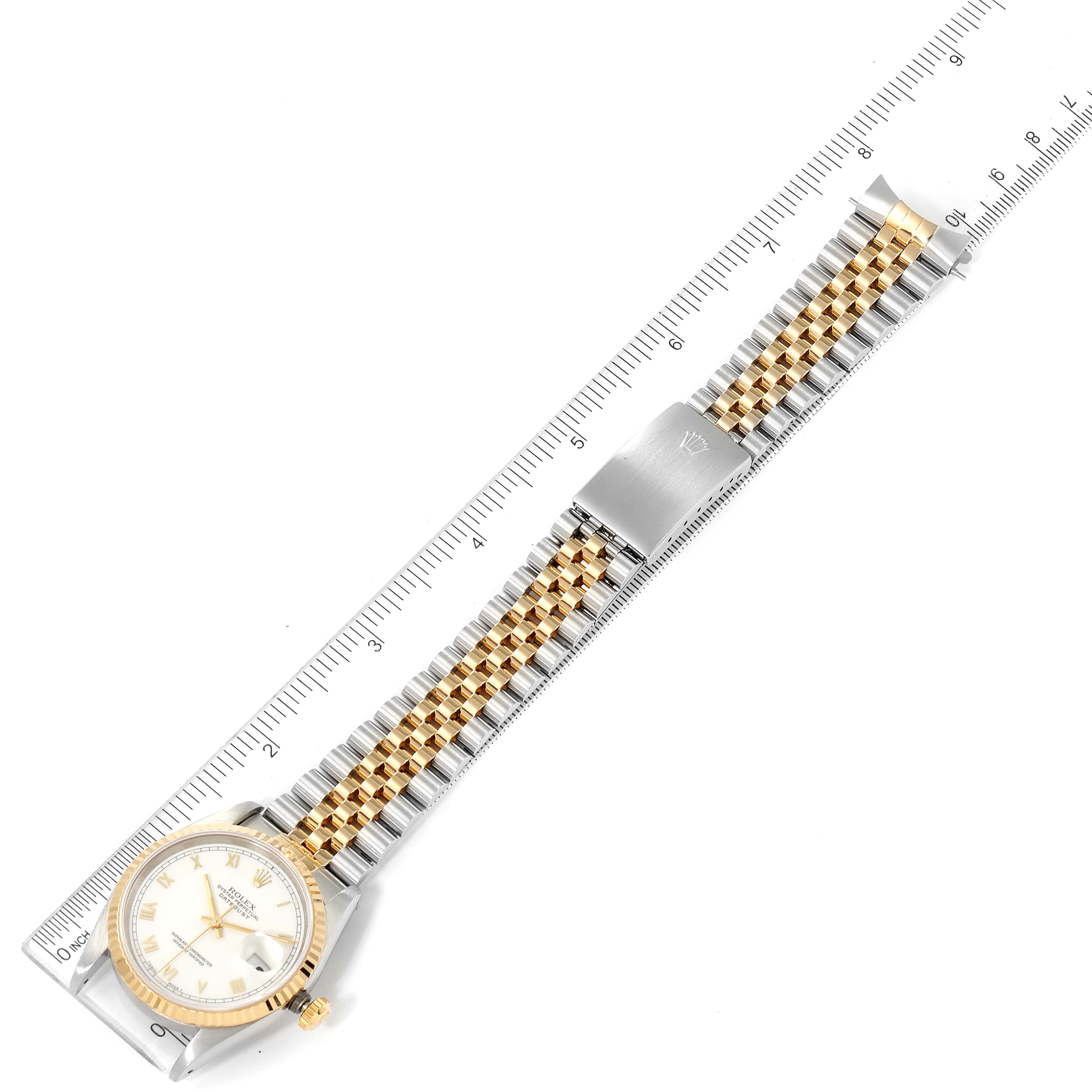 The image shows an overhead view of a Rolex Datejust 16233 Men's Steel and Gold (two tone) White Dial 16233 Men's Steel and Gold (two tone) White Dial watch with its bracelet extended along a ruler.