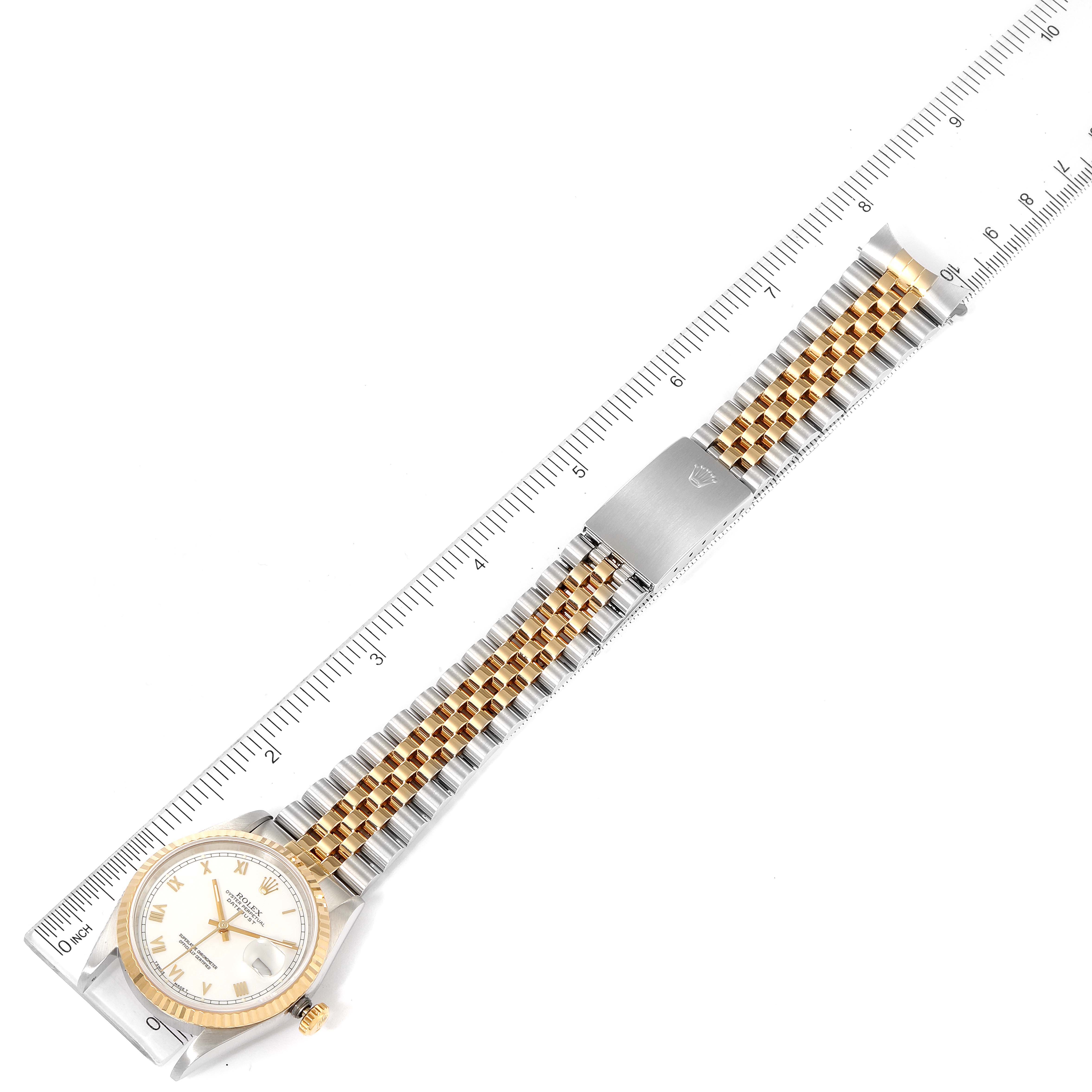 The Rolex Datejust 16233 Men's Steel and Gold (two tone) White Dial 16233 Men's Steel and Gold (two tone) White Dial watch is shown lying flat with its face, two-tone bracelet, and clasp visible alongside a ruler.