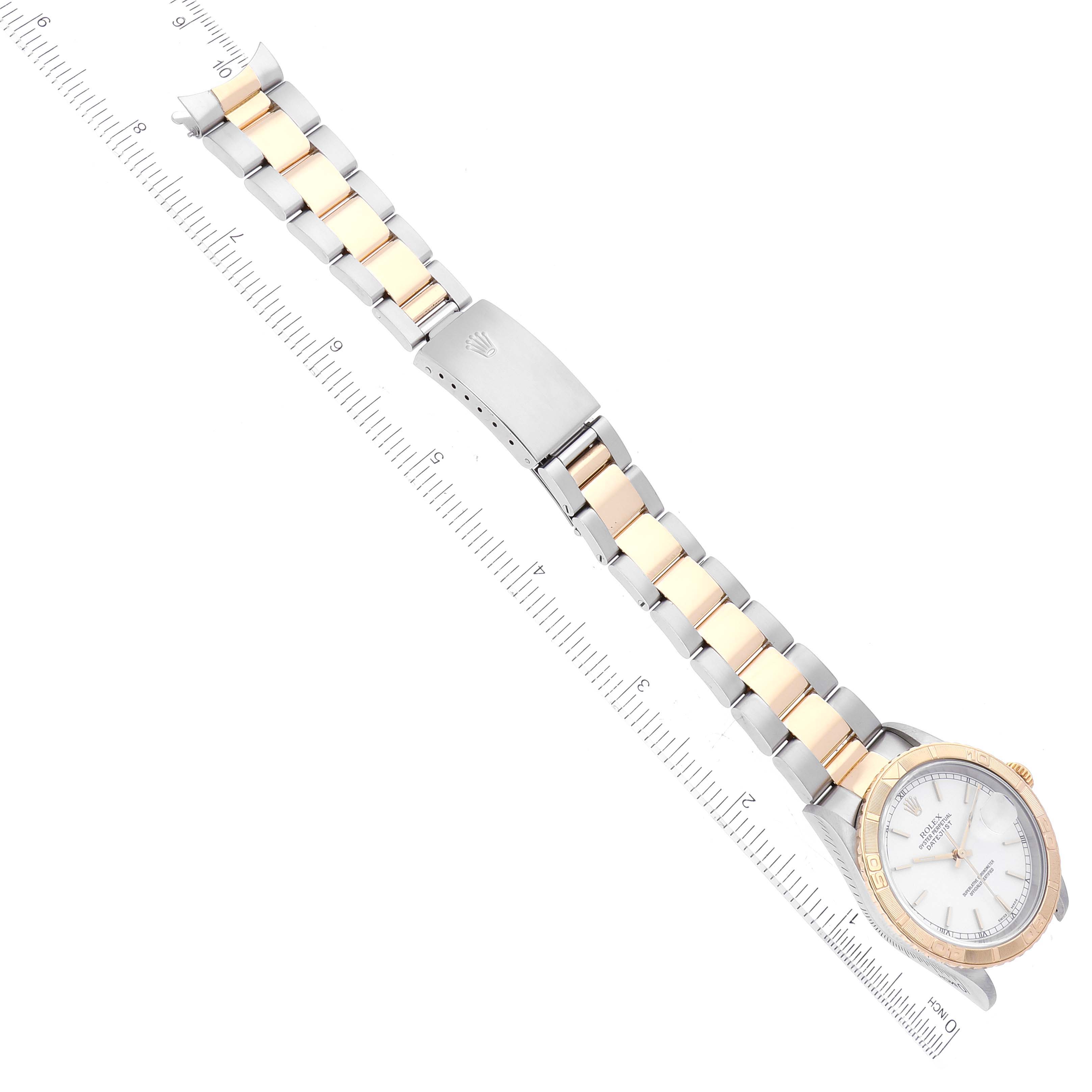 The Rolex Turn-o-Graph 16263 Men's Steel and Gold (two tone) White Dial 16263 Men's Steel and Gold (two tone) White Dial watch is shown at a diagonal angle, displaying the face, bezel, and full bracelet with a clasp and ruler for scale.