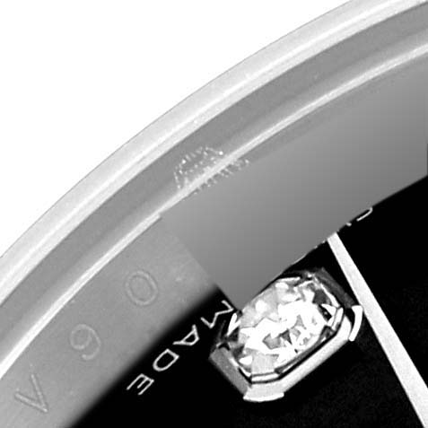 This close-up image of a Rolex Datejust 179174 Women's Stainless Steel Black Dial 179174 Women's Stainless Steel Black Dial watch shows part of its bezel, dial, and a diamond hour marker.