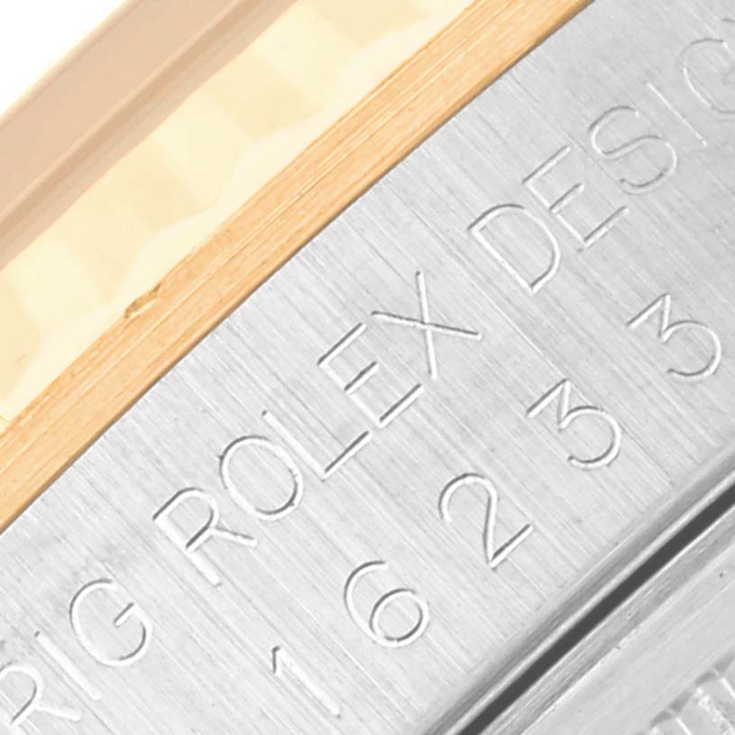 This close-up image shows the engraved lettering on the side of a Rolex Datejust 16233 Men's Steel and Gold (two tone) White Dial 16233 Men's Steel and Gold (two tone) White Dial watch bezel.