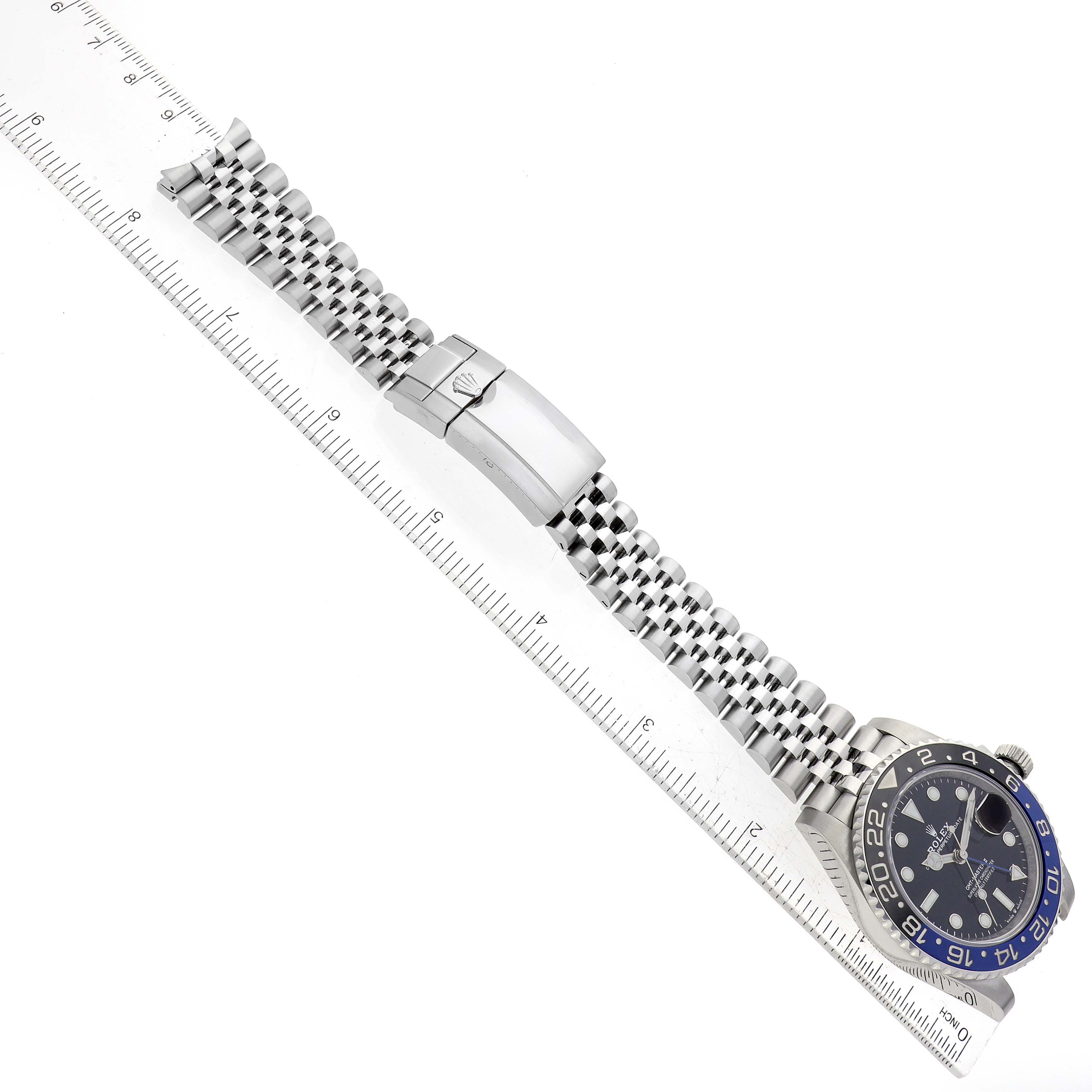 The image shows a top-down view of a Rolex GMT-Master 126710BLNR Men's Stainless Steel Black Dial 126710BLNR Men's Stainless Steel Black Dial watch, displaying the dial, bezel, bracelet, and clasp against a ruler.