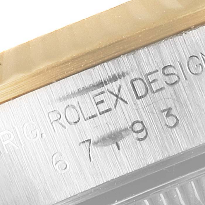 The image shows a close-up angle of the serial and model number engraving on a Rolex Oyster Perpetual 67193 Women's Steel and Gold (two tone) Black Dial 67193 Women's Steel and Gold (two tone) Black Dial watch.