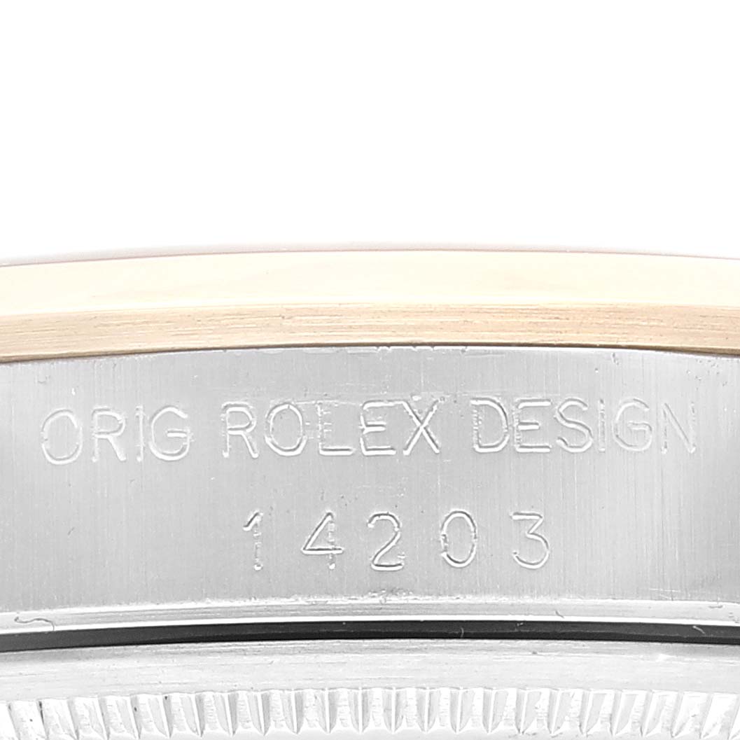 The image shows a close-up view of the side of the Rolex Oyster Perpetual 14203 Men's Steel and Gold (two tone) Grey Dial 14203 Men's Steel and Gold (two tone) Grey Dial watch case, highlighting the engraved text.