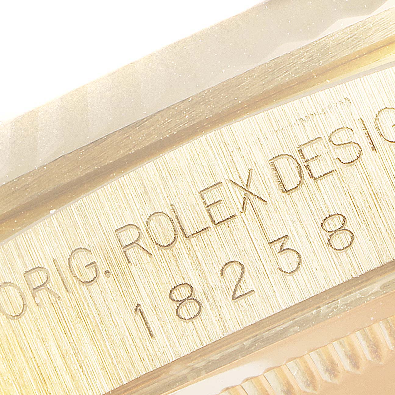 The image shows an extreme close-up of the side of the Rolex President 18238 Men's Yellow Gold Champagne Dial 18238 Men's Yellow Gold Champagne Dial model, featuring the engraved reference number.