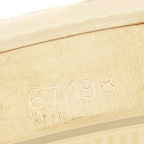 The image shows a close-up of the case edge of the Rolex President 67198 Women
s Yellow Gold Champagne Dial 67198 Women
s Yellow Gold Champagne Dial model, featuring engraved numbers "67198".