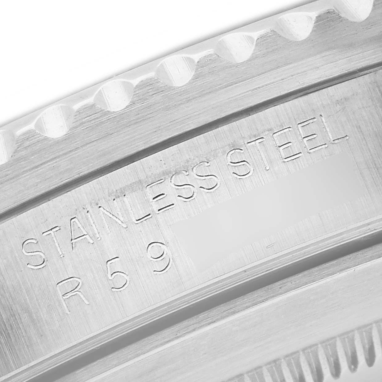 This image shows a close-up of the engraved "STAINLESS STEEL" on the bezel of a Rolex Vintage Collection 168000 Men's Stainless Steel Black Dial 168000 Men's Stainless Steel Black Dial watch.