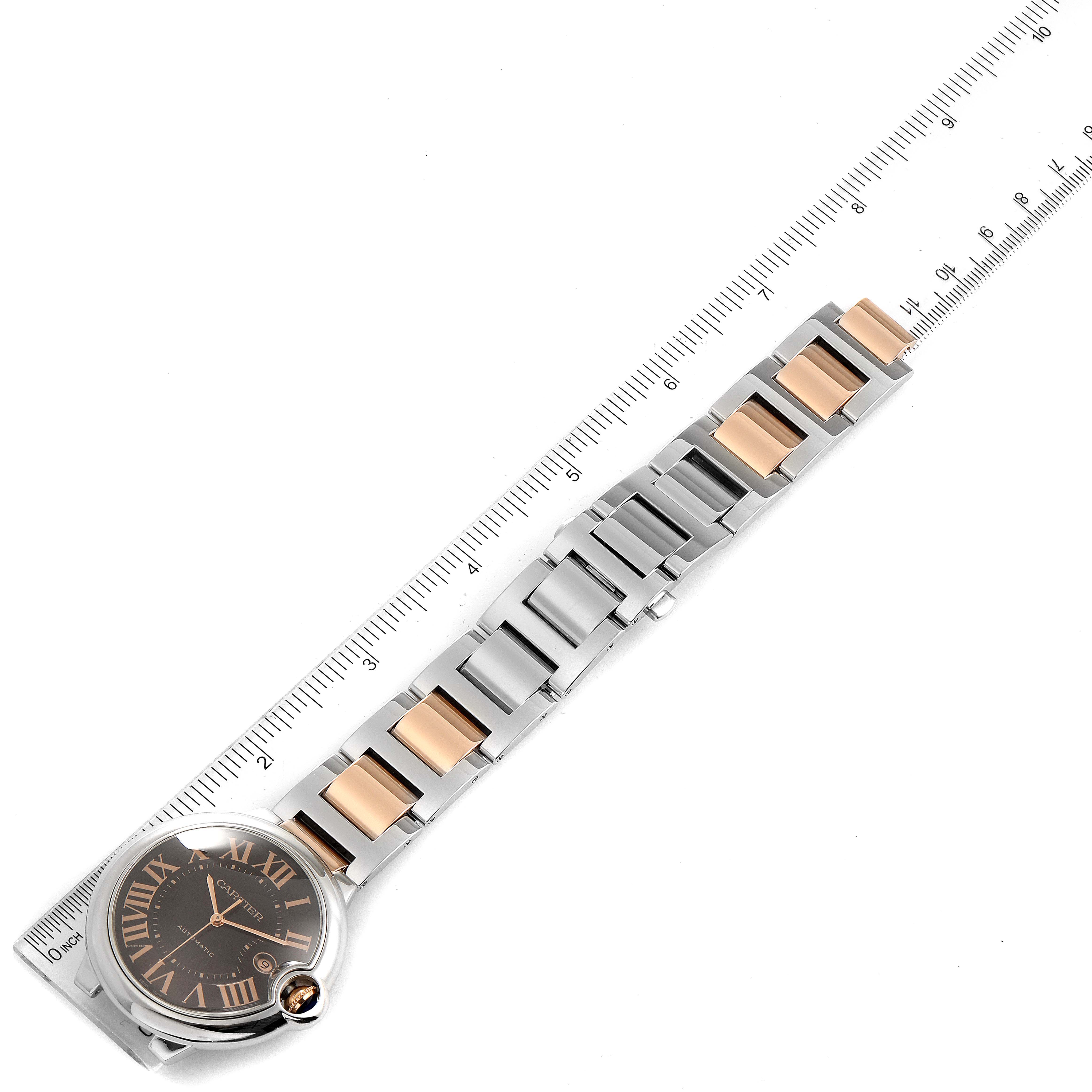 The image shows a top-view of a Ballon Bleu model by Cartier, featuring the watch face and part of the metal strap on a ruler.