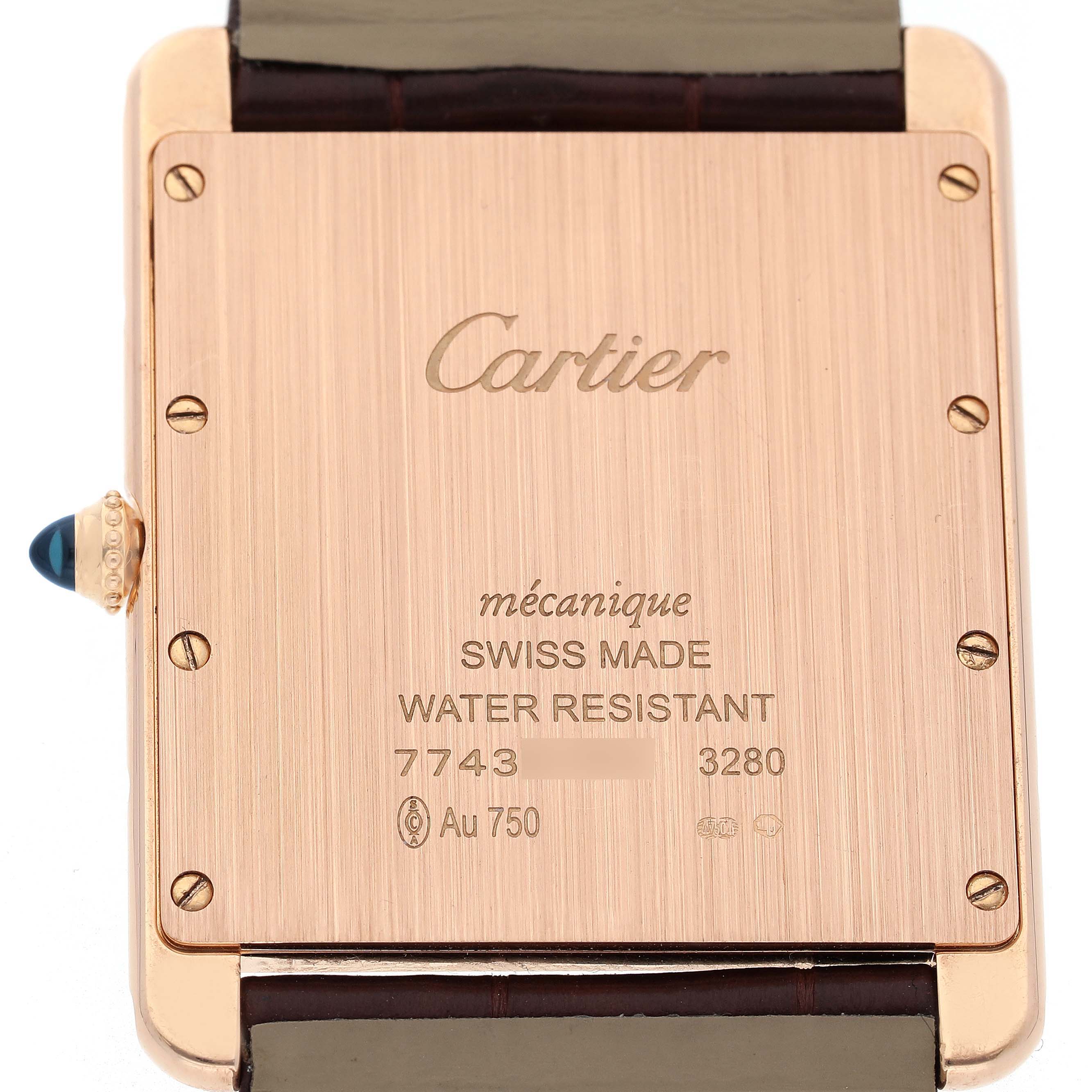 The image shows the backplate of the Tank Louis Cartier watch, displaying engravings and a cabochon crown.