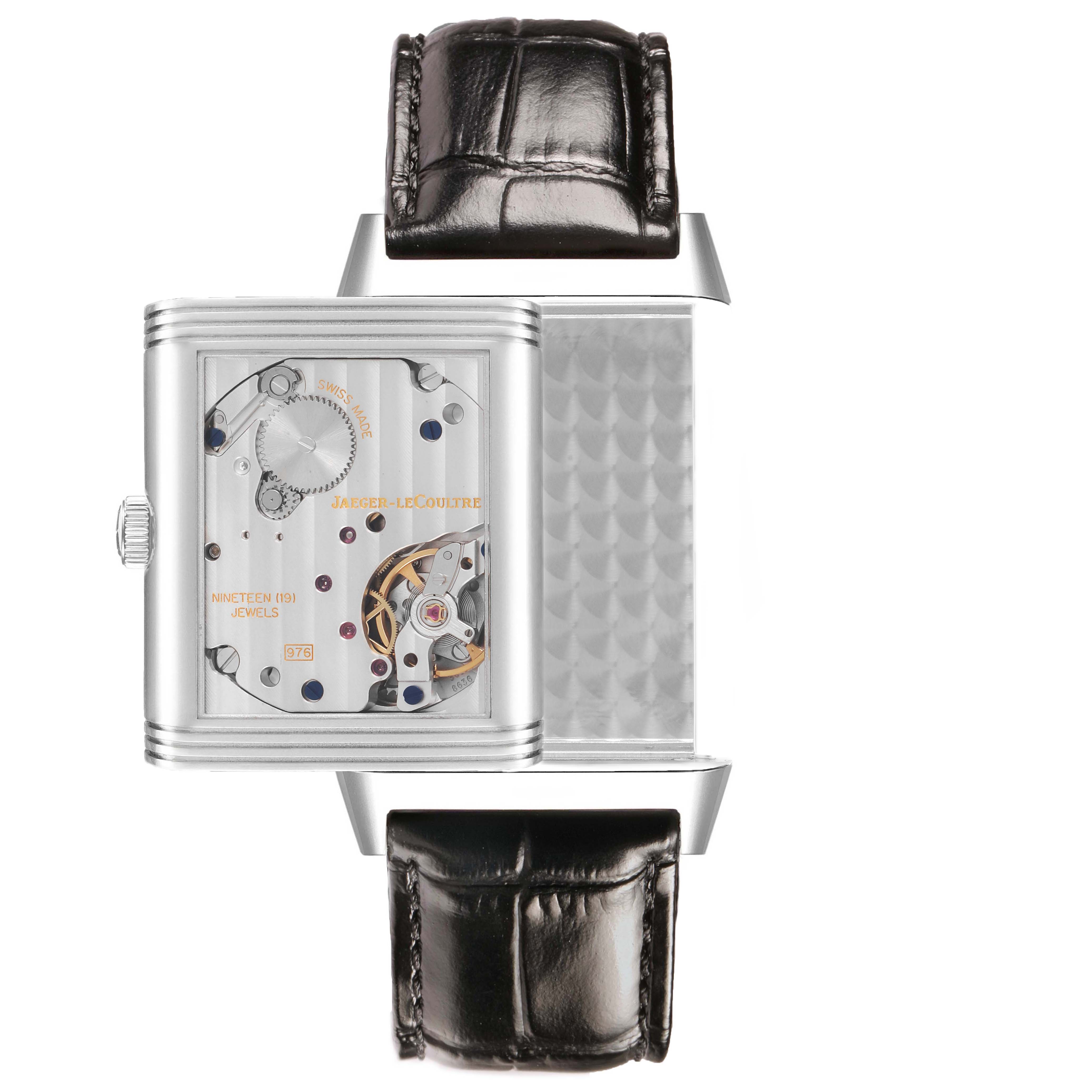 The image shows a Jaeger-LeCoultre Reverso watch from the side, displaying its mechanical movement and part of the strap.