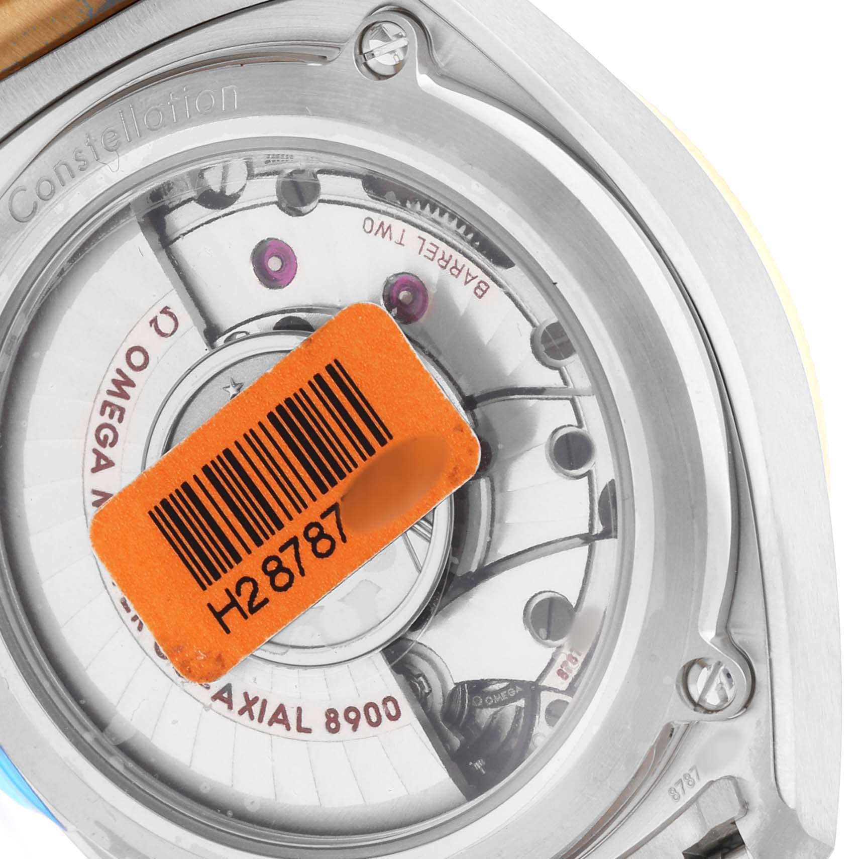 The image shows the back of an Omega Constellation 130.20.39.21.02.001 Men's Stainless Steel Silver Dial watch, highlighting the movement and a barcode sticker.