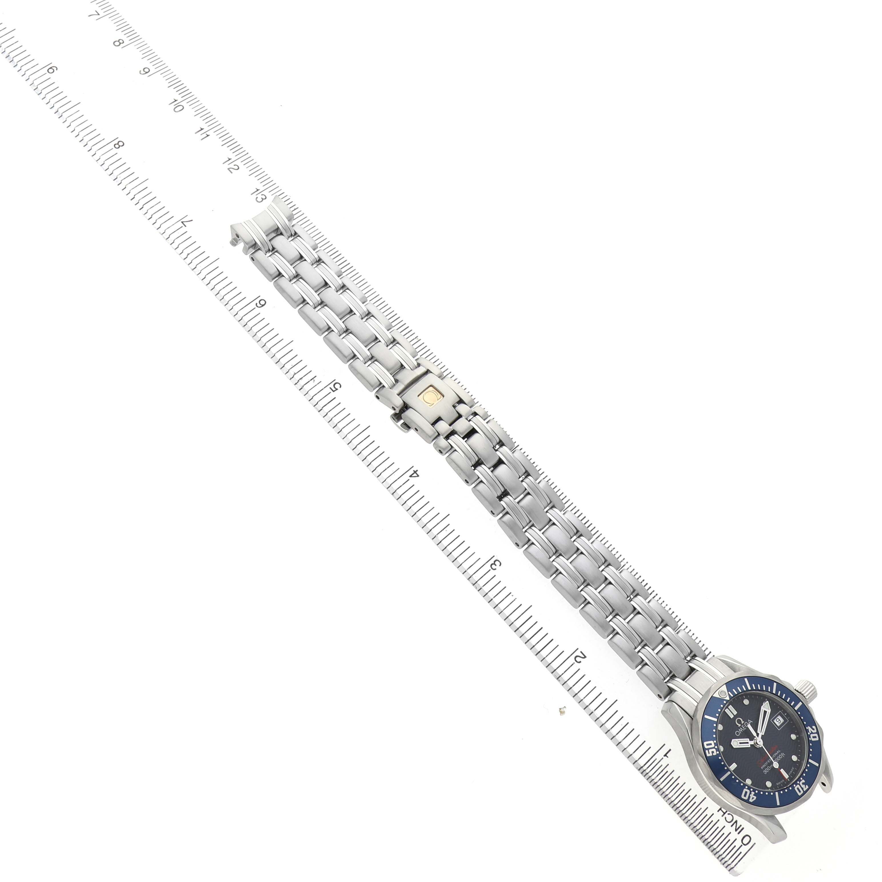 The Omega 2224.80.00 Women's Stainless Steel Blue Dial Seamaster Diver 300M Steel Blue Dial Ladies Watch is shown from an overhead angle alongside a ruler, displaying the band and bezel.