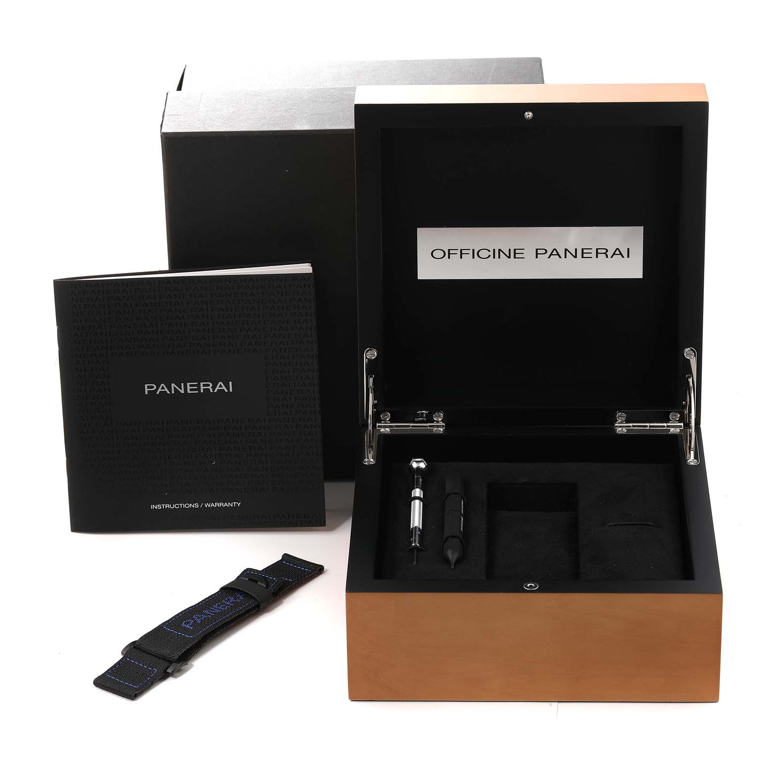 The image shows an open Panerai Luminor PAM00764 Men's Titanium Black Dial PAM00764 Men's Titanium Black Dial watch box with a booklet, strap, and tools from a front angle.