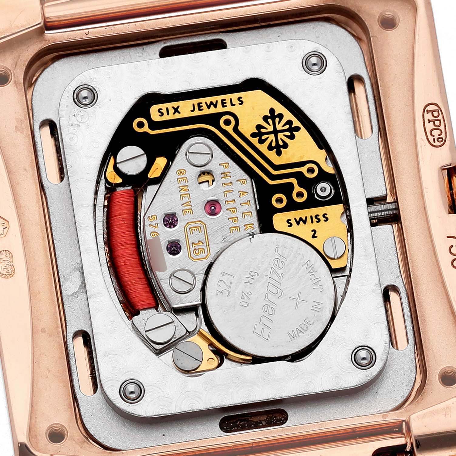 The image shows the back of a Patek Philippe Twenty-4 4920R-010 Women's Rose Gold Silver Dial watch, revealing the movement and battery components.