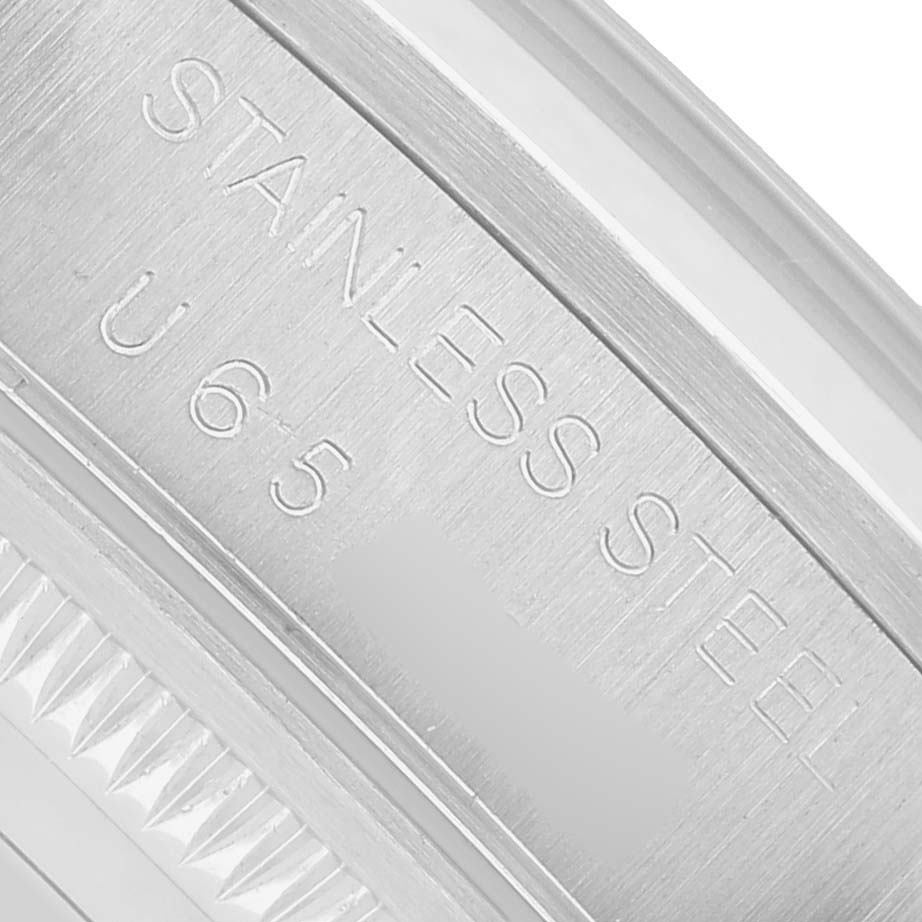 The image shows a close-up of the side engraving on a Rolex Date Men's Stainless Steel Pink Dial model, highlighting the "STAINLESS STEEL" text.