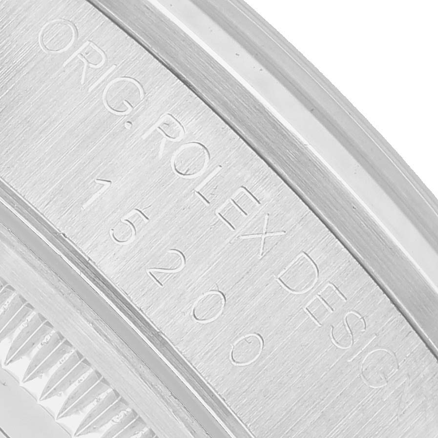 The image shows an angled view of the engraved case back of a Rolex Date Men's Stainless Steel Pink Dial model watch, highlighting the serial number.
