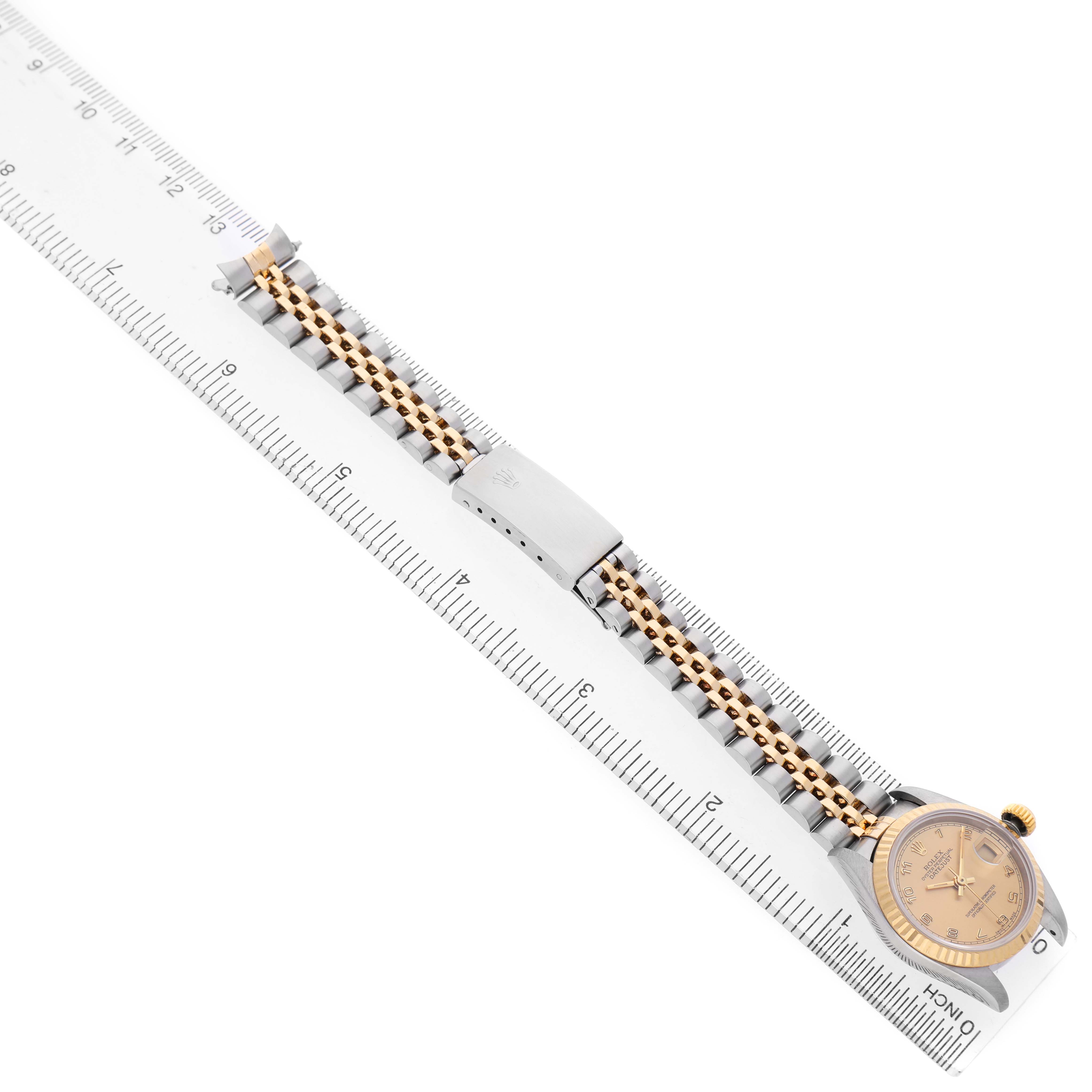 The Rolex Datejust 69173 Women's Stainless Steel Champagne Dial watch is shown laid flat with the face, bracelet, and clasp visible against a ruler.