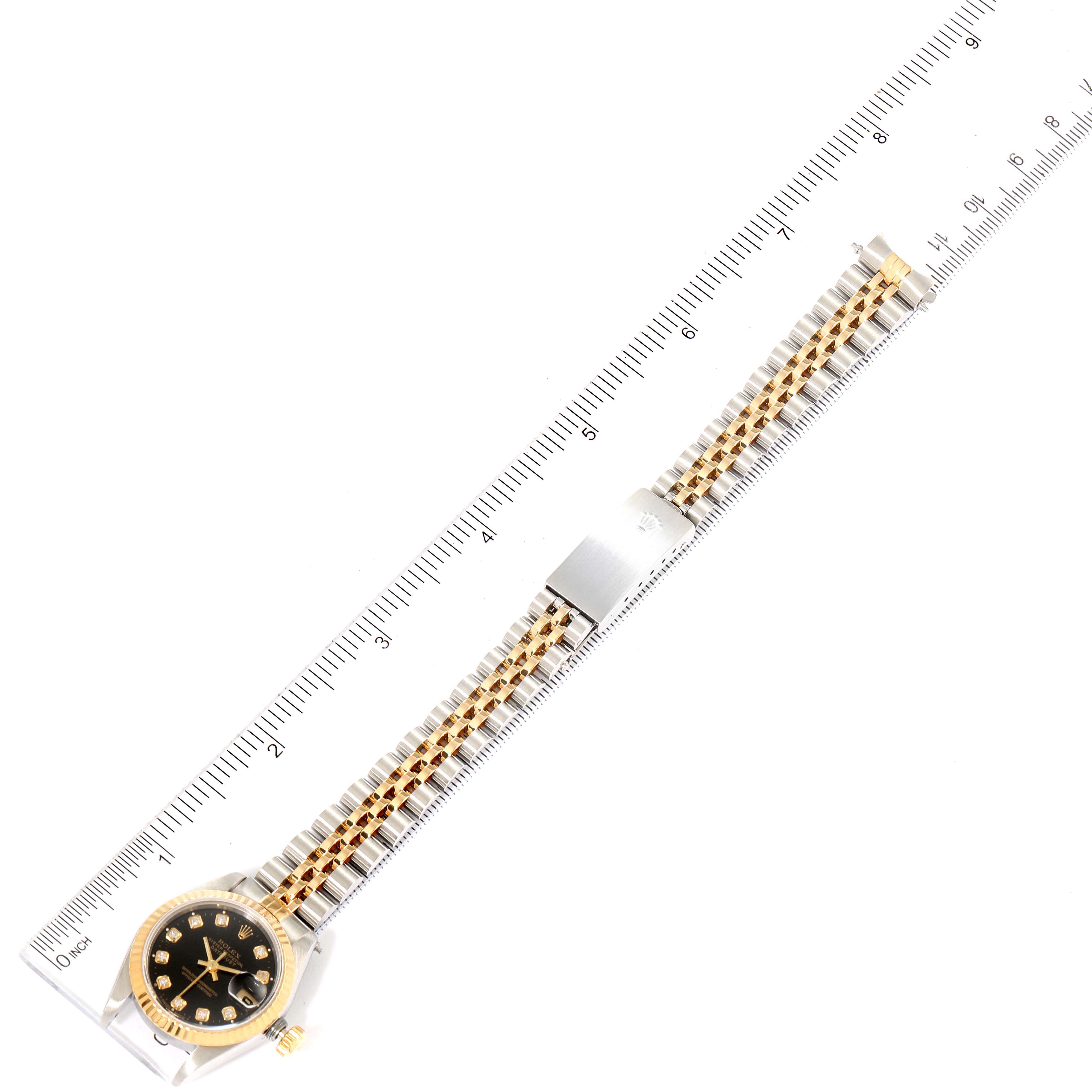 A top-down view of a Rolex Datejust 69173 Women's Steel and Gold (two tone) Black Dial 69173 Women's Steel and Gold (two tone) Black Dial watch shows the full band and face, laid next to a ruler for scale.