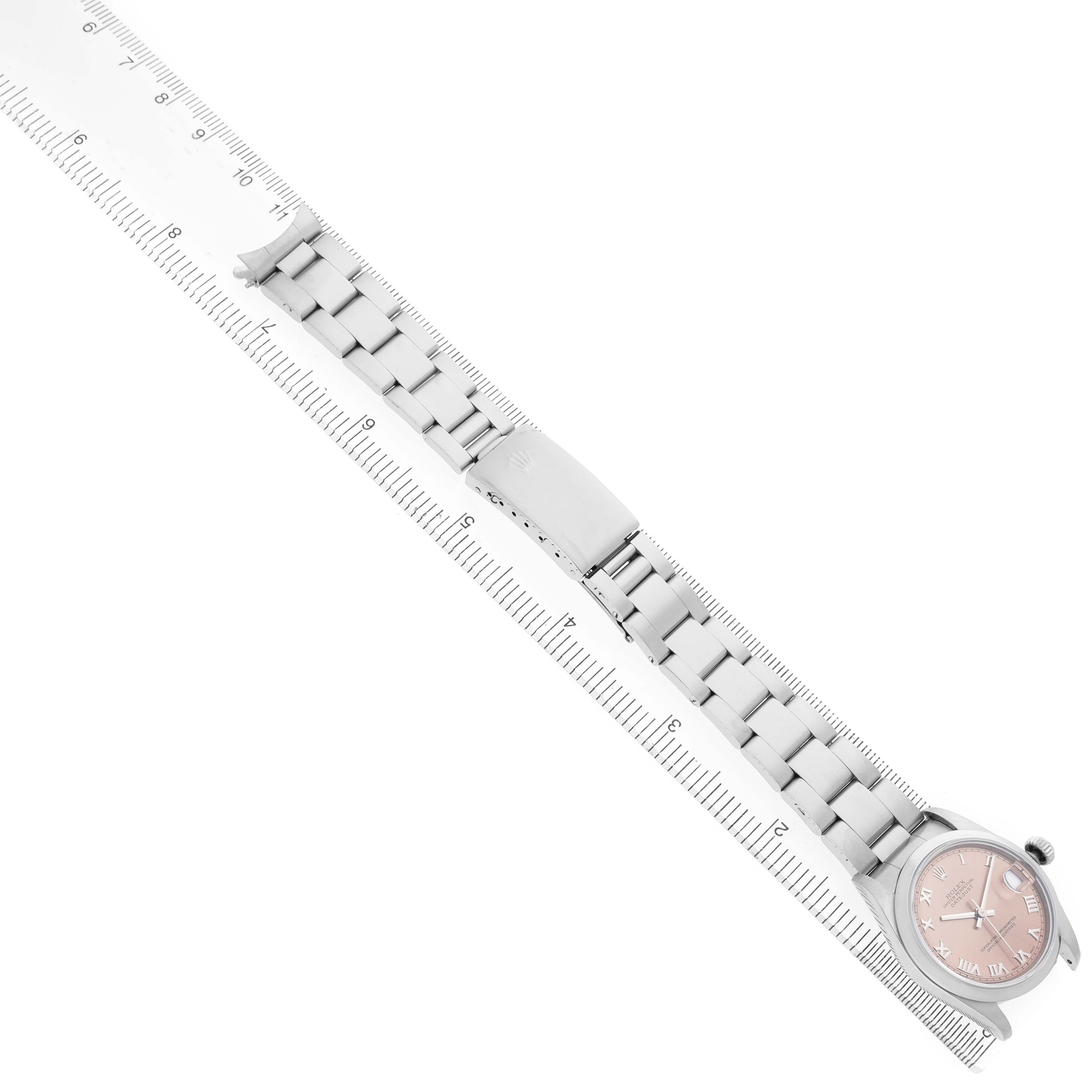 The image shows a Rolex Mid-Size 68240 Women's Stainless Steel Pink Dial watch from a top view, highlighting the dial, bezel, and bracelet alongside a ruler for scale.