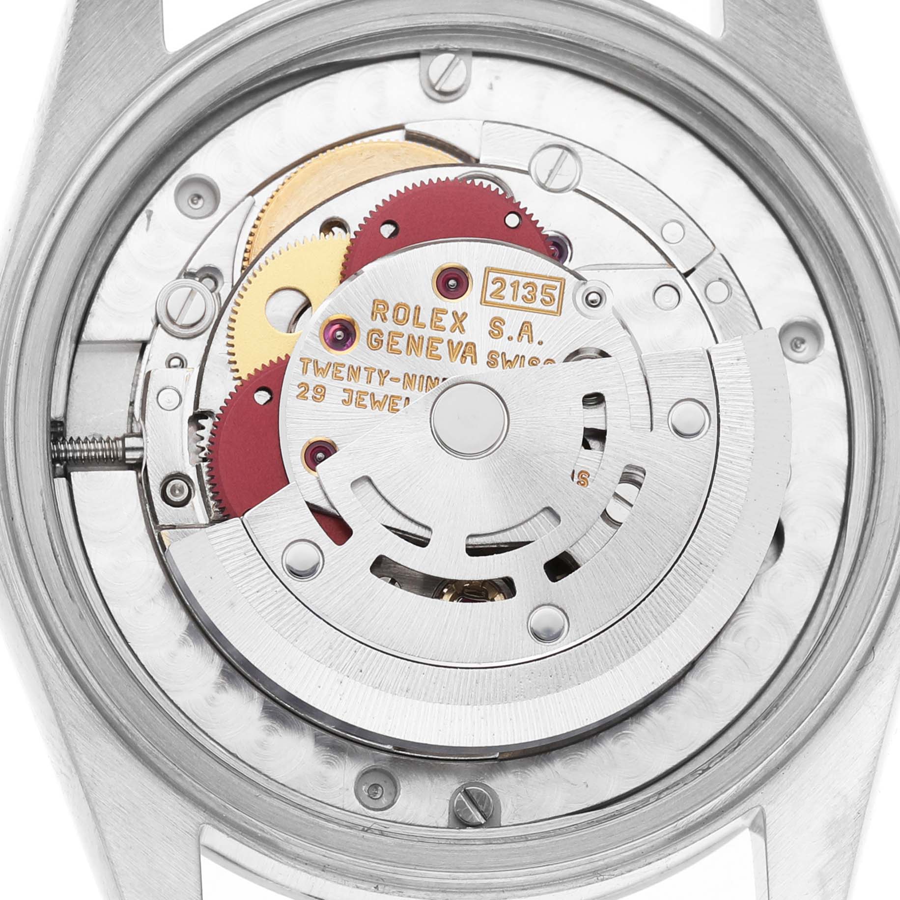 The image shows the movement of a Mid-Size Rolex watch, viewed from the back, revealing gears and inscriptions.