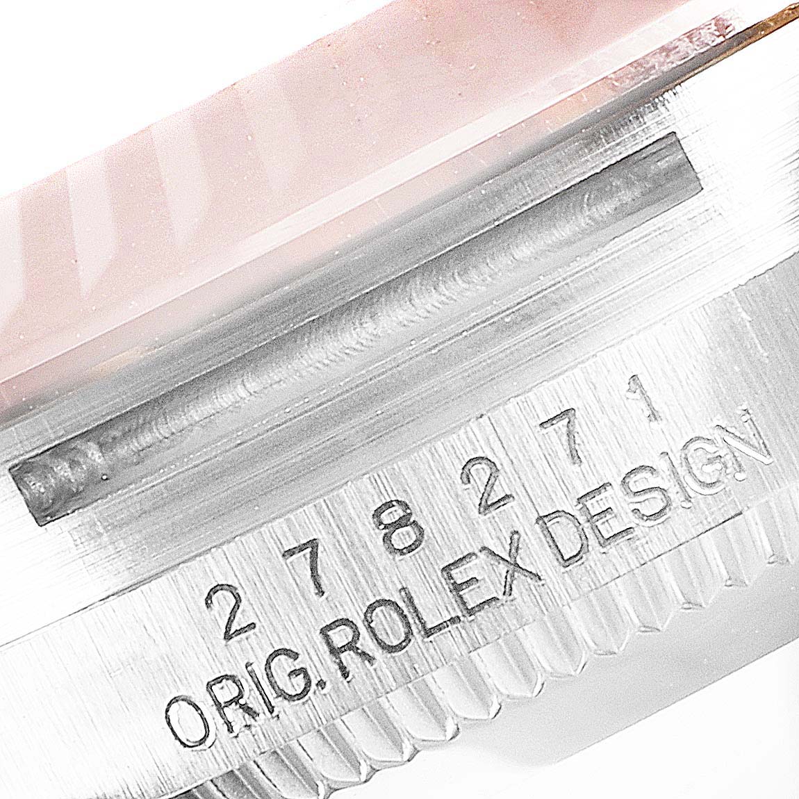 The image shows a close-up of a part of a Mid-Size Rolex watch case with the "ORIG. ROLEX DESIGN" engraving and reference number.